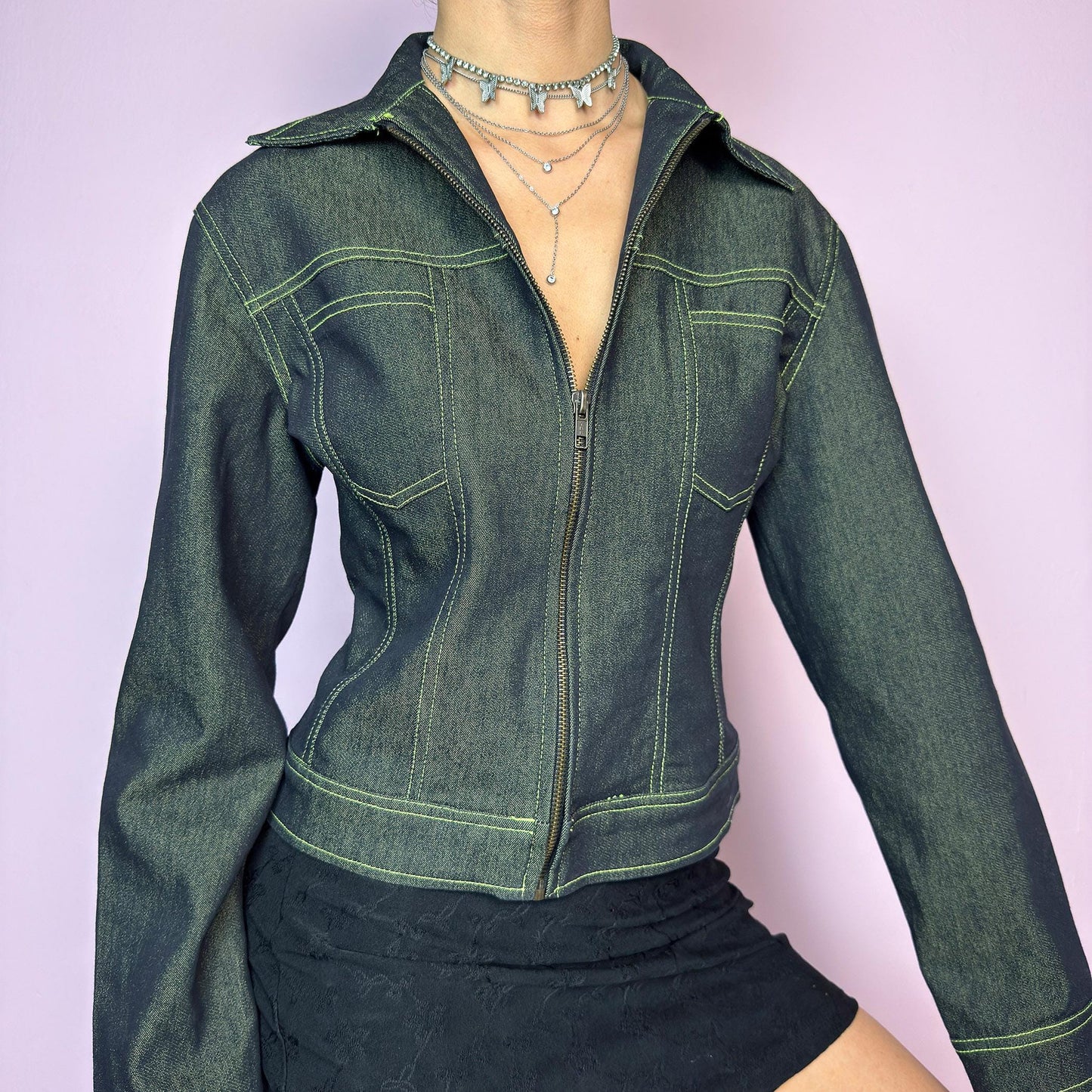 The Y2K Dark Denim Jacket is a vintage 2000s denim piece with a fitted cut and structured silhouette. Crafted in a dark rinse wash that gives it a sleek finish. Features a full front zip closure, bold panel seam construction, and sharp collar. The standout detail? Neon contrast stitching that adds a futuristic, eye-catching touch. A statement layering piece. Excellent vintage condition. adult world shop