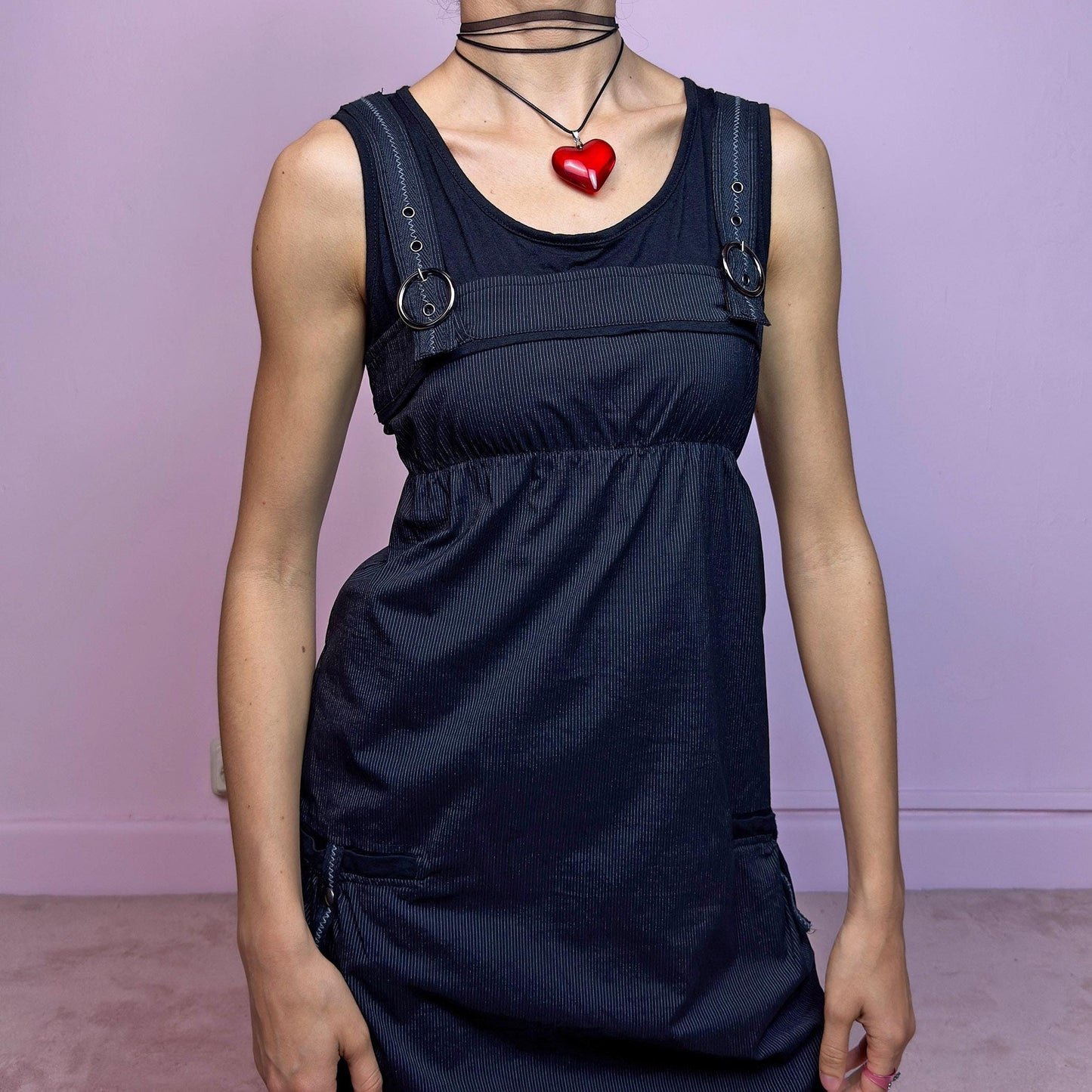 The Y2K Black Striped Bubble Mini Dress is a rare vintage 2000s piece with a playful techwear vibe. Features subtle vertical pinstripes, silver-tone D-rings on the straps, and functional side pockets. The ruched bubble hem adds volume and edge, while the stretchy fabric and empire waist provide a flattering fit. Finished with a side zipper closure for easy wear. Perfect for cybercore, Y2K streetwear, or Harajuku-inspired looks. Excellent vintage condition.
