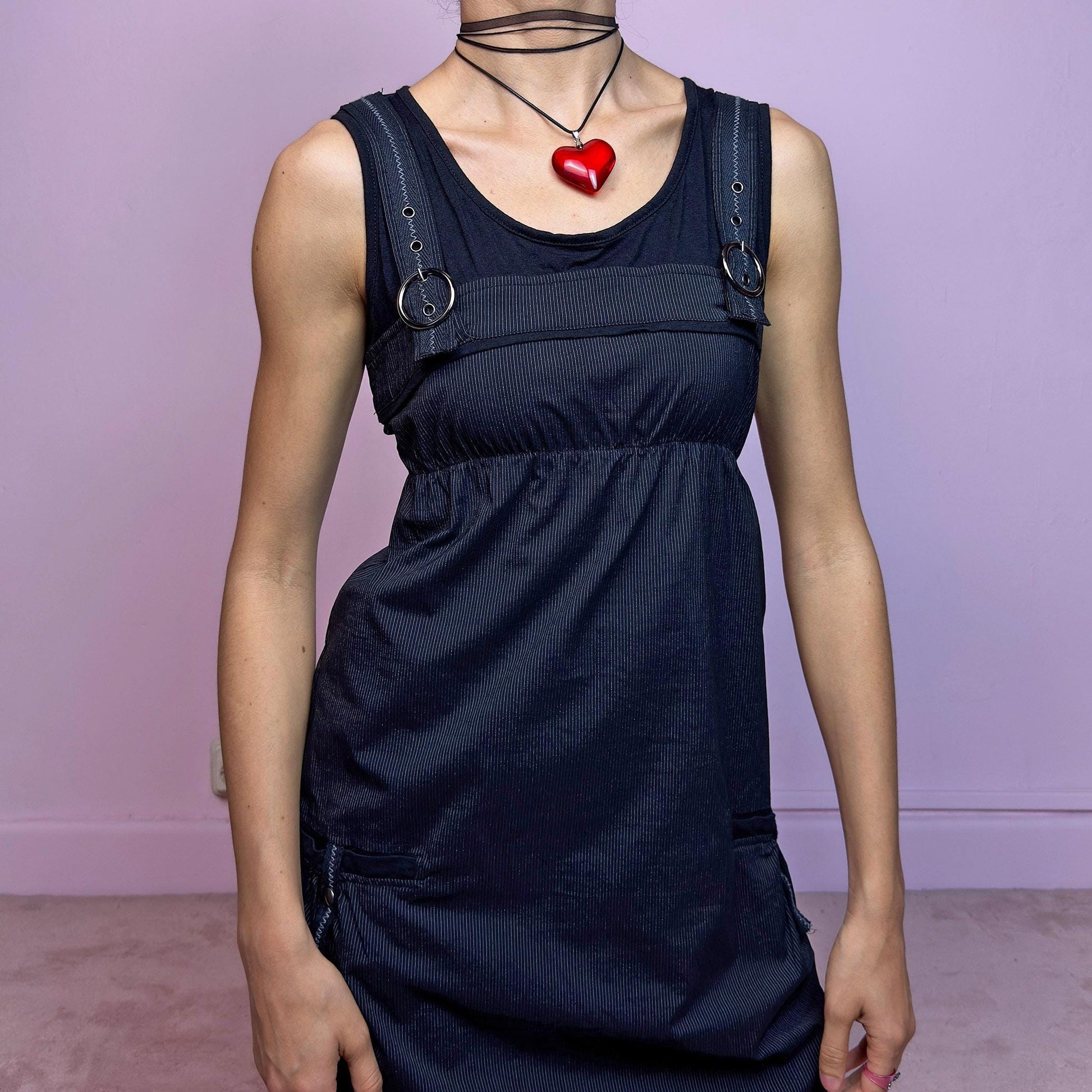 The Y2K Black Striped Bubble Mini Dress is a rare vintage 2000s piece with a playful techwear vibe. Features subtle vertical pinstripes, silver-tone D-rings on the straps, and functional side pockets. The ruched bubble hem adds volume and edge, while the stretchy fabric and empire waist provide a flattering fit. Finished with a side zipper closure for easy wear. Perfect for cybercore, Y2K streetwear, or Harajuku-inspired looks. Excellent vintage condition.