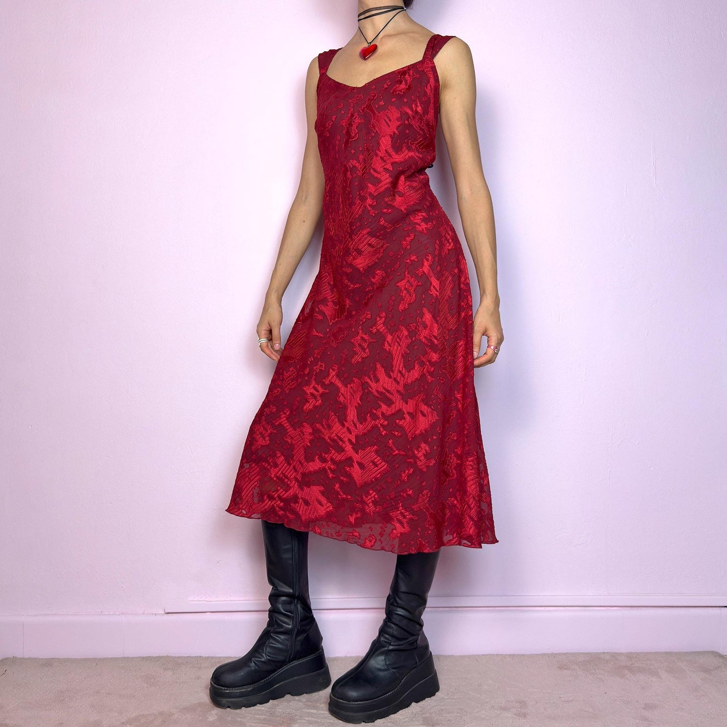 The Vintage 90s Maroon Textured Midi Dress is a romantic and striking piece in a rich maroon tone with abstract textured patterns and a sheer overlay. Designed with wide straps, a flattering sweetheart neckline, and a flowy midi-length cut. The semi-sheer fabric adds depth while the inner lining provides comfort. Perfect for formal events, romantic nights, or gothic glam looks. Elegant, timeless, and effortlessly dramatic. Excellent vintage condition.