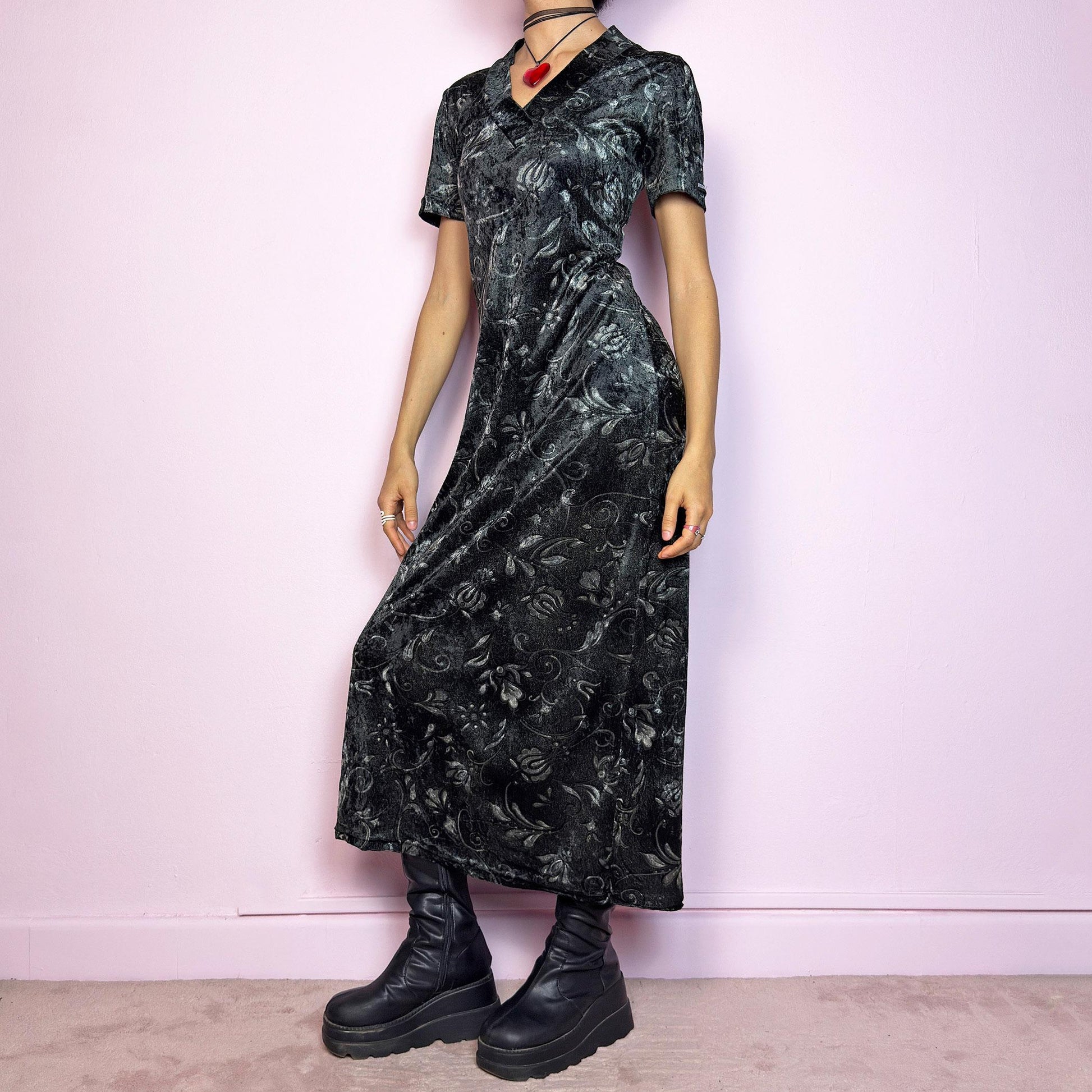 The Vintage 90s Gray Velvet Midi Dress is a moody and elegant 90s piece made from soft, stretchy dark gray velvet with a baroque-style printed pattern. Features a flattering V-neckline, short sleeves, and a sleek longline silhouette. The velvety fabric gives it a luxurious feel while staying comfy. Perfect for witchy aesthetics, gothic romance, or vintage night-out looks.