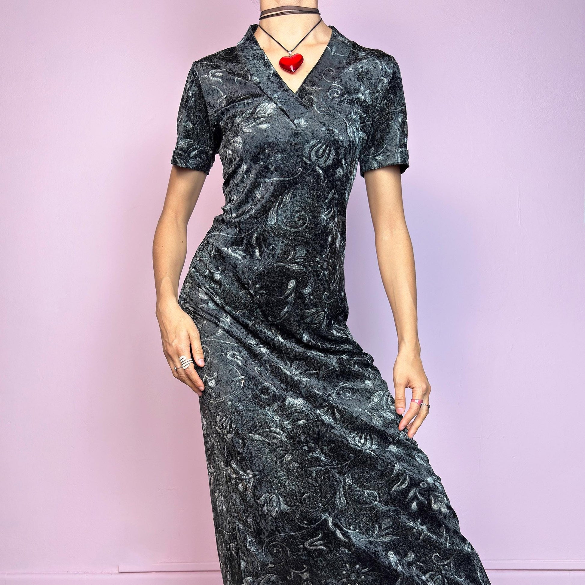 The Vintage 90s Gray Velvet Midi Dress is a moody and elegant 90s piece made from soft, stretchy dark gray velvet with a baroque-style printed pattern. Features a flattering V-neckline, short sleeves, and a sleek longline silhouette. The velvety fabric gives it a luxurious feel while staying comfy. Perfect for witchy aesthetics, gothic romance, or vintage night-out looks.