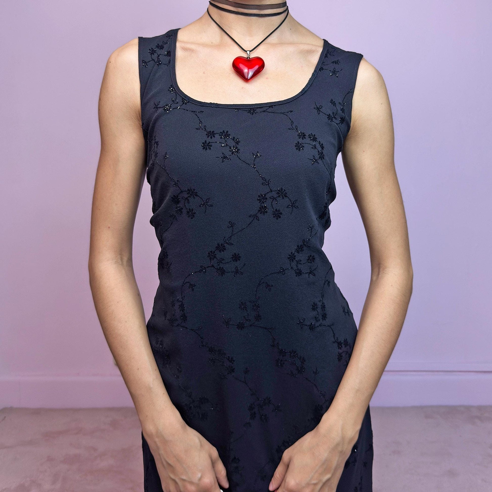 The Vintage 90s Black Mesh Mini Dress is a delicate and stretchy black mini dress featuring sheer mesh overlay with velvet floral embroidery and subtle glitter accents. Designed with a flattering sleeveless silhouette, scoop neckline, and lettuce hem for a soft romantic touch. Perfect for witchy party looks, 90s glam nights, or layering with grunge accessories. Made in UK. Excellent vintage condition.