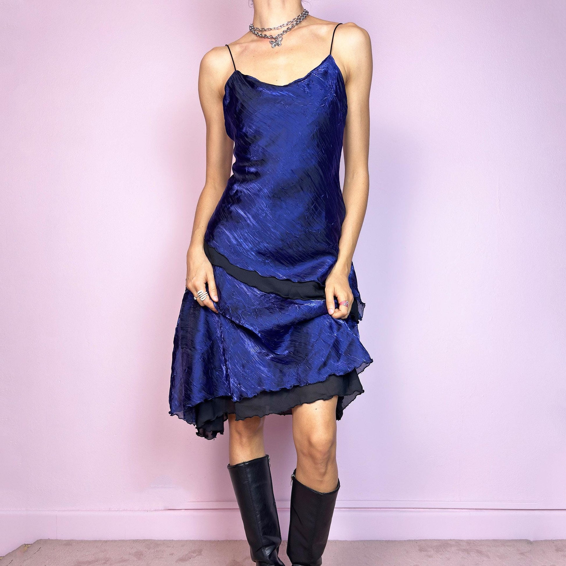 This vintage 90s midi dress features rich cobalt blue crinkled fabric over a black base with asymmetric layered panels. The fluid A-line silhouette and thin spaghetti straps create soft movement and luminous drape. Made from lightweight material with no stretch. A romantic and timeless piece for formal summer occasions—elegant, sculptural, and made to be remembered. Excellent vintage condition.