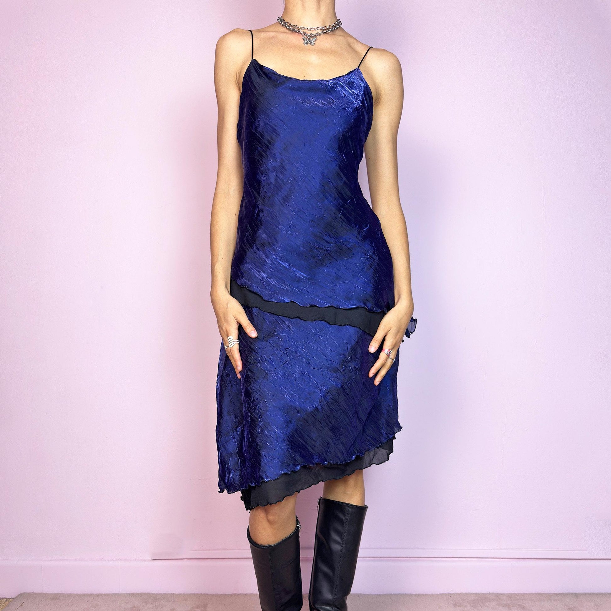 This vintage 90s midi dress features rich cobalt blue crinkled fabric over a black base with asymmetric layered panels. The fluid A-line silhouette and thin spaghetti straps create soft movement and luminous drape. Made from lightweight material with no stretch. A romantic and timeless piece for formal summer occasions—elegant, sculptural, and made to be remembered. Excellent vintage condition.