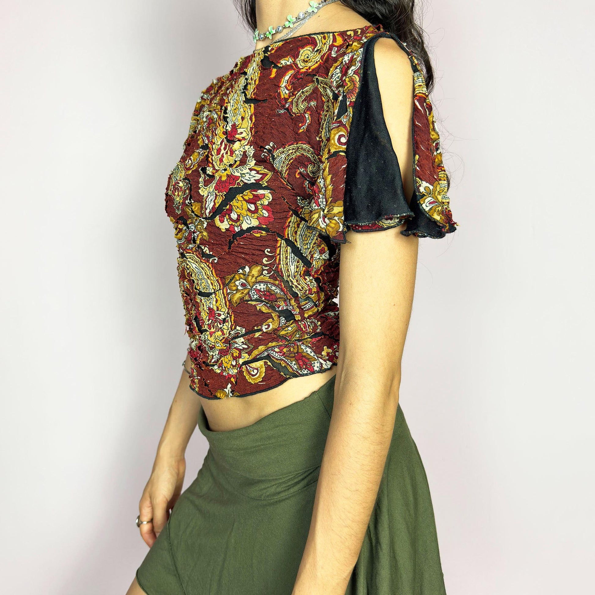 This vintage 2000s crinkle mesh top stuns with yellow-gold paisley prints on a rich maroon base and a dramatic split short sleeve. Ideal for summer nights, art parties, or elegant outdoor dinner looks. A rare, textile-rich piece with gypsy-bohemian undertones and free-spirited dancing energy. Made of stretch polyester blend. Great vintage condition.