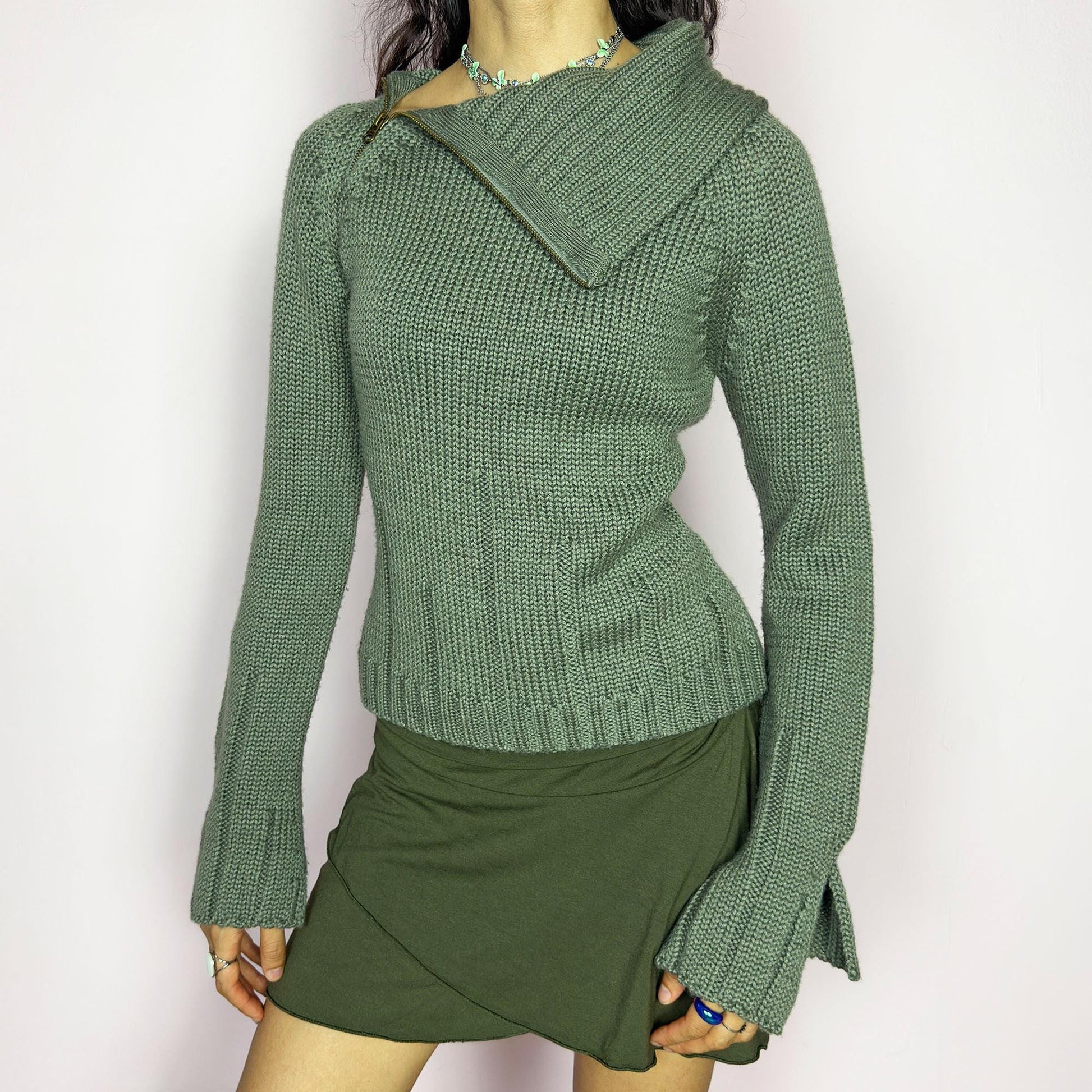 This vintage 2000s green knit sweater features a dramatic asymmetrical collar with exposed zipper and flared split cuffs. Ideal for deconstructed layering on autumn days, it radiates fairy grunge energy with a streetwear edge. A fluffy Y2K piece made of acrylic and wool for cozy warmth. Great vintage condition.