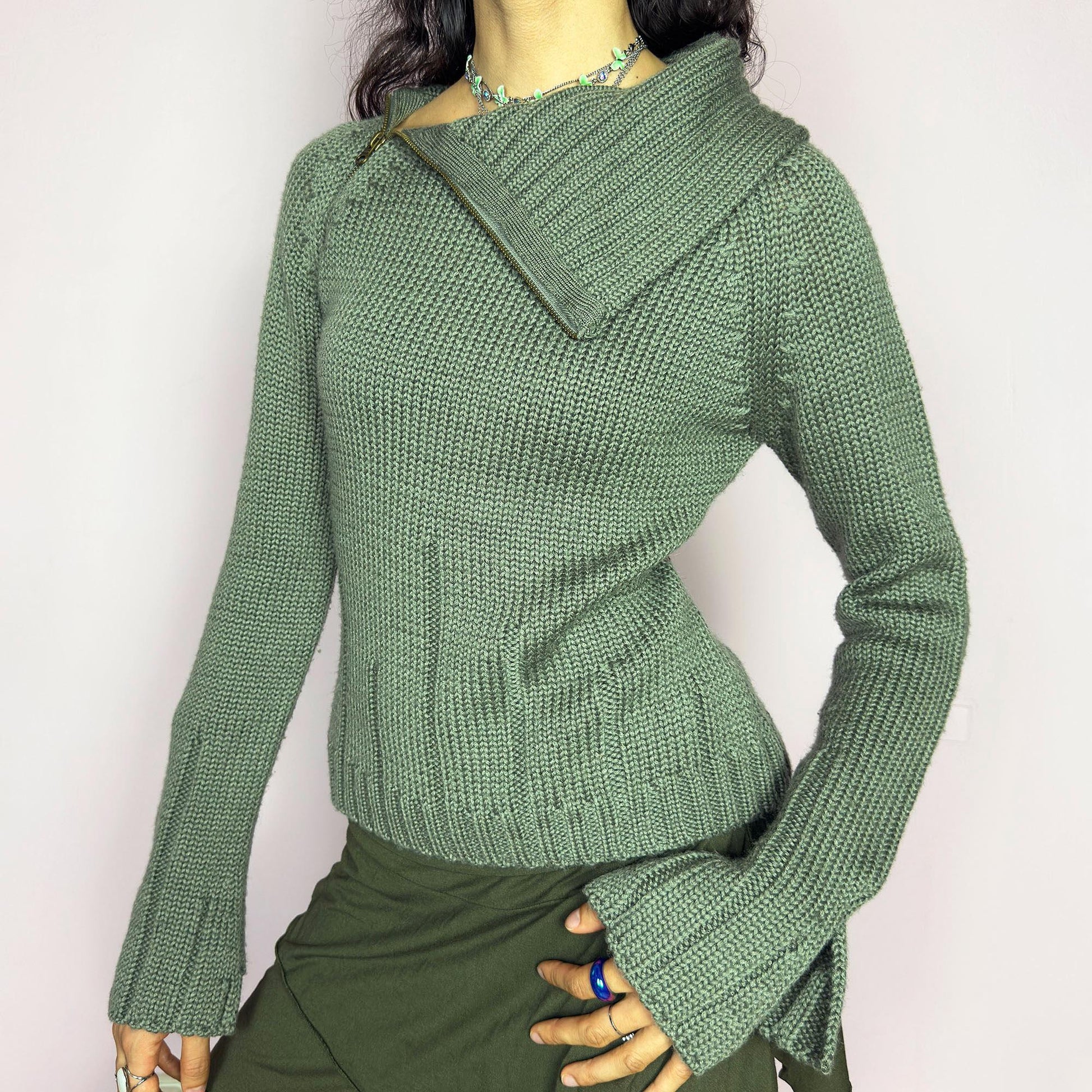 This vintage 2000s green knit sweater features a dramatic asymmetrical collar with exposed zipper and flared split cuffs. Ideal for deconstructed layering on autumn days, it radiates fairy grunge energy with a streetwear edge. A fluffy Y2K piece made of acrylic and wool for cozy warmth. Great vintage condition.