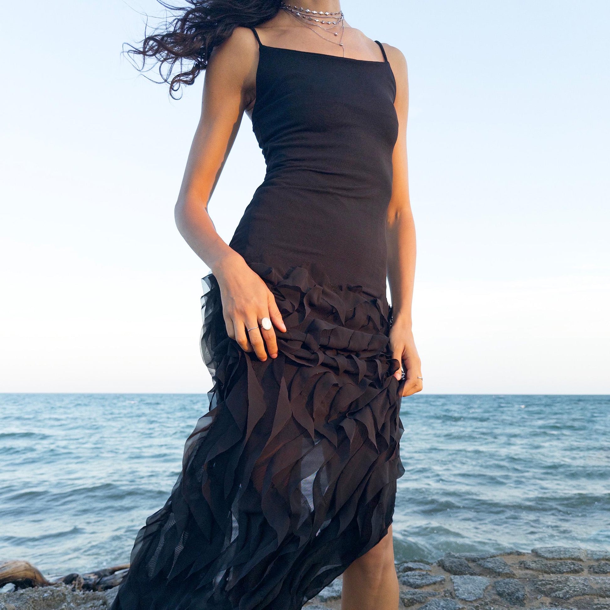 The vintage 90s black mesh midi dress is a sculptural piece with sheer wave appliqué layered across the skirt, minimalist neckline, and a back slit for fluidity. Its body-skimming silhouette fuses quiet sensuality with architectural edge. Ideal for city nights, gallery parties, or modern cocktail looks. An avant garde archive find made in the USA from a stretchy polyester blend. Excellent vintage condition.
