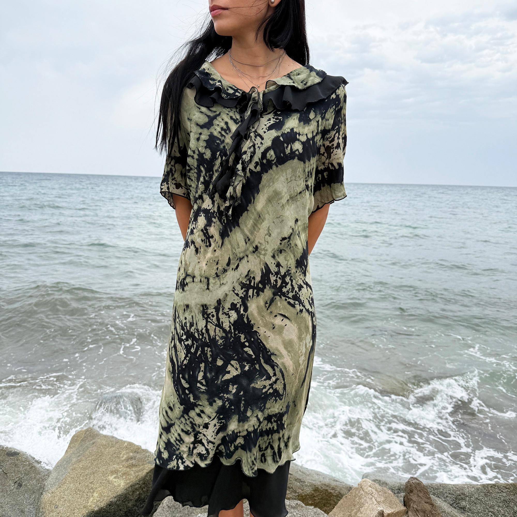This vintage 90s midi dress features a black and green tie-dye pattern with a ruffled neckline. The short sleeves and flowy layered hem make it ideal for summer festivals, boho gatherings, or dark fairy-inspired looks. A unique Italian-made piece, perfect for forest parties or artistic styling. Made in Italy from lightweight non-stretch fabric. Excellent vintage condition.