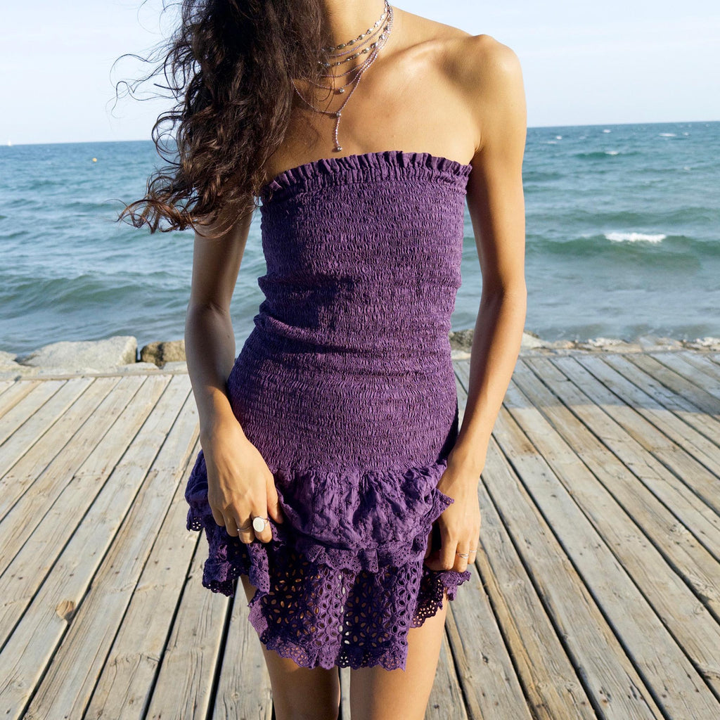 The vintage 90s purple strapless mini dress is a sunlit dream in ruched cotton with tiered ruffle lace hems. Made in Italy, its smocked bodice hugs the figure while the eyelet and broderie anglaise layers add texture and movement. Lightweight and easy, it channels boho fairy energy—perfect for holidays, summer parties, or barefoot cocktail hours. A romantic resort piece with sun-drenched charm. Great vintage condition.