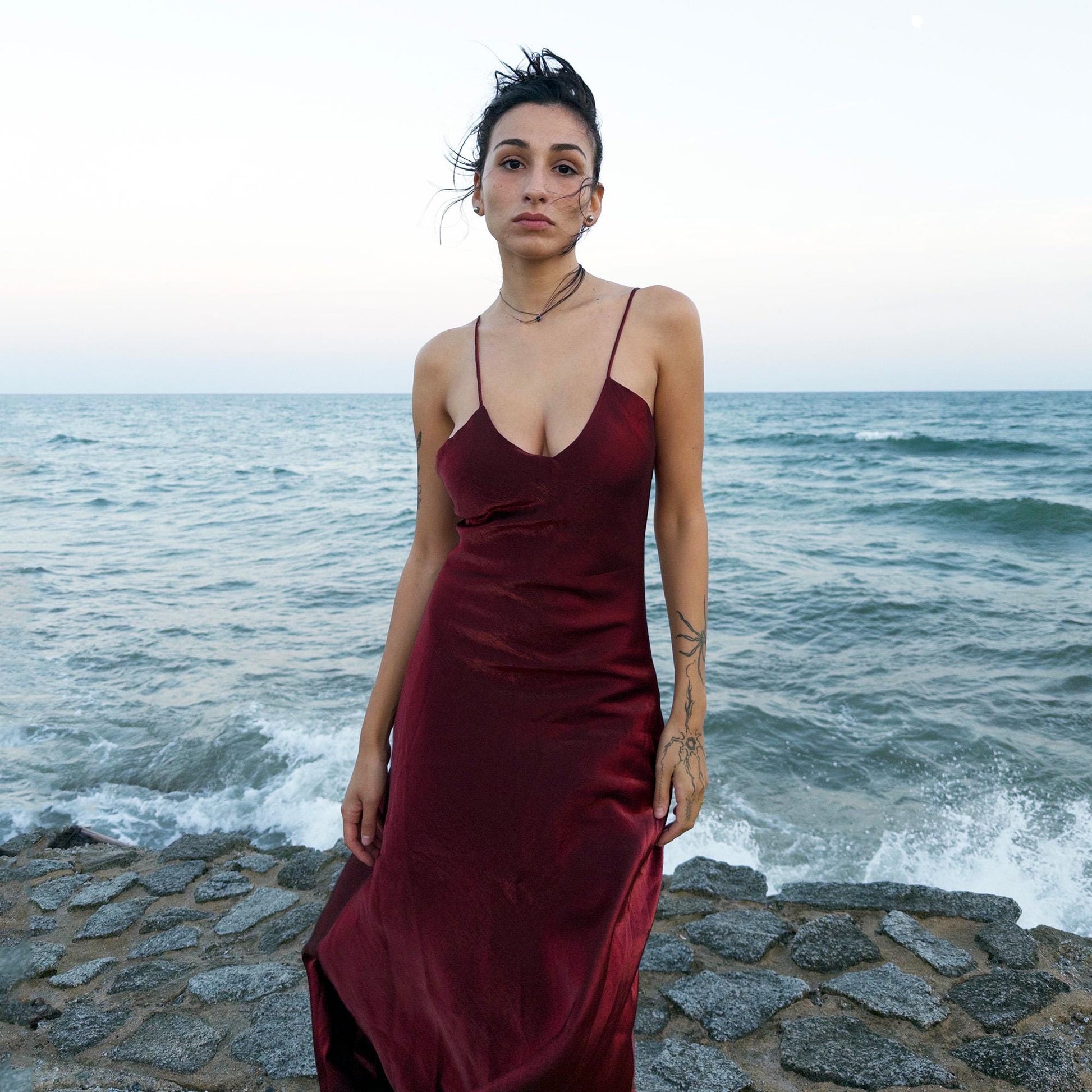 The vintage 2000s maroon slip dress is a French-made piece with high-shine finish, fluid silhouette, and delicate spaghetti straps. Its glossy depth and body-skimming cut evoke diva glamour and red carpet allure. Ideal for summer nights, cocktails, or sensual evening entrances. A romantic burgundy Y2K archive gown made from a non-stretch polyester blend fabric. Excellent vintage condition.