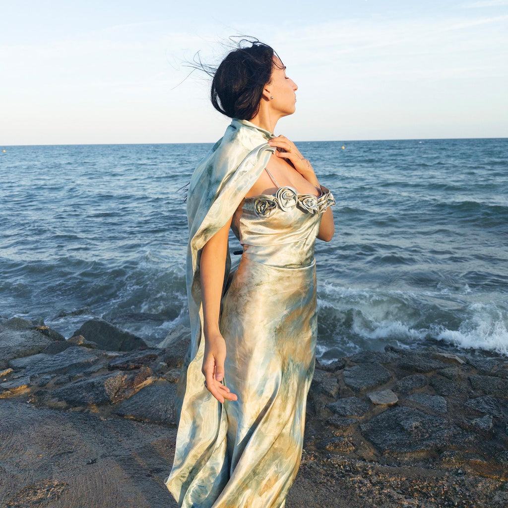 The vintage 2000s pastel tie-dye slip dress is a French-made fantasy in soft blues, greens, and gold. With sculptural rosette appliqué along the bust and a matching scarf, it moves like light on water. The shiny satin-style finish and fluid midi length evoke fairytale softness—ideal for proms, weddings, or summer nights. A romantic Y2K archive crafted from a shimmering non-stretch polyester blend. Great vintage condition.