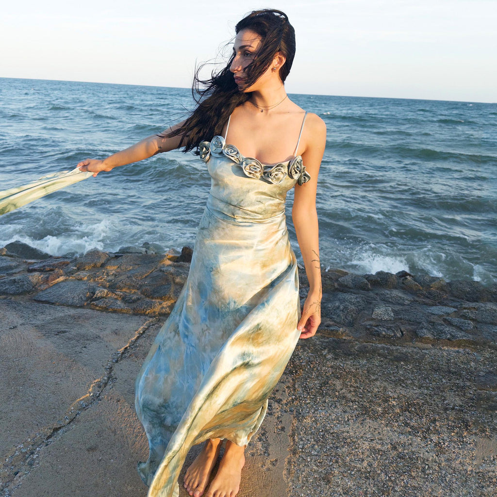 The vintage 2000s pastel tie-dye slip dress is a French-made fantasy in soft blues, greens, and gold. With sculptural rosette appliqué along the bust and a matching scarf, it moves like light on water. The shiny satin-style finish and fluid midi length evoke fairytale softness—ideal for proms, weddings, or summer nights. A romantic Y2K archive crafted from a shimmering non-stretch polyester blend. Great vintage condition.