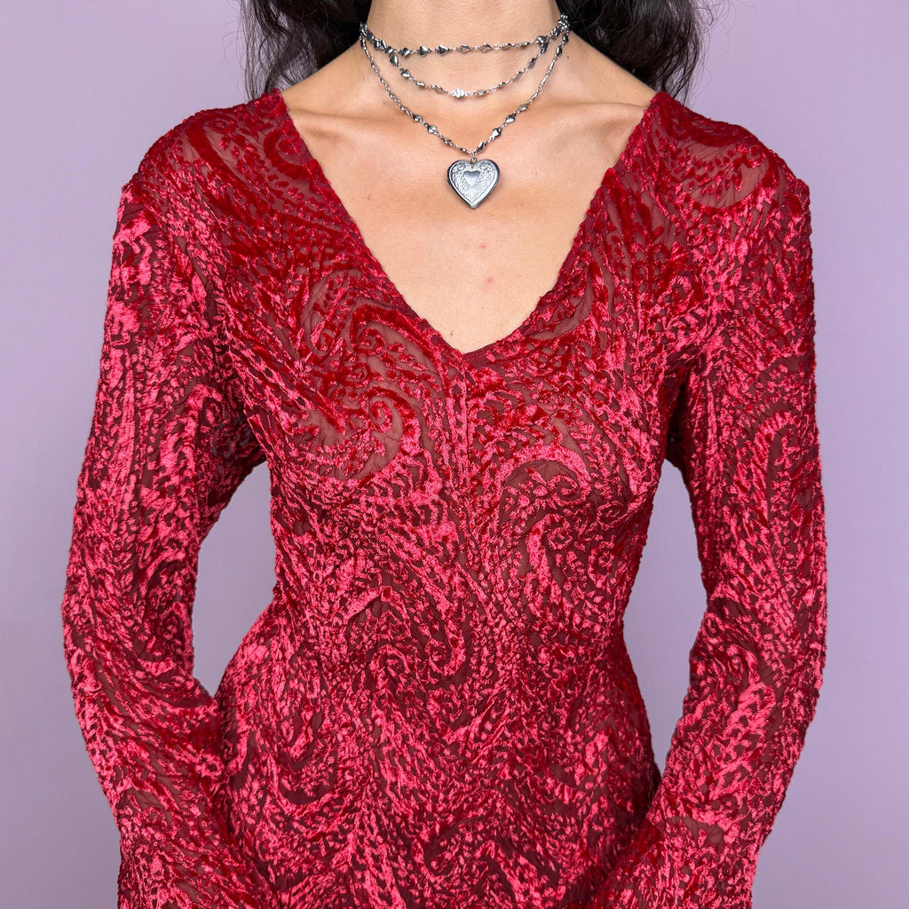 This vintage 2000s top features a dramatic red velvet devoré burnout design with sheer detailing. Styled with asymmetric bell sleeves, a fitted silhouette, and a flared hem, it creates a striking romantic look. Perfect for parties, festivals, or statement evening wear, this Y2K piece captures glamorous gothic energy with artistic flair. A rare archival French design. Made from a stretchy polyester blend devoré velvet. Excellent vintage condition.