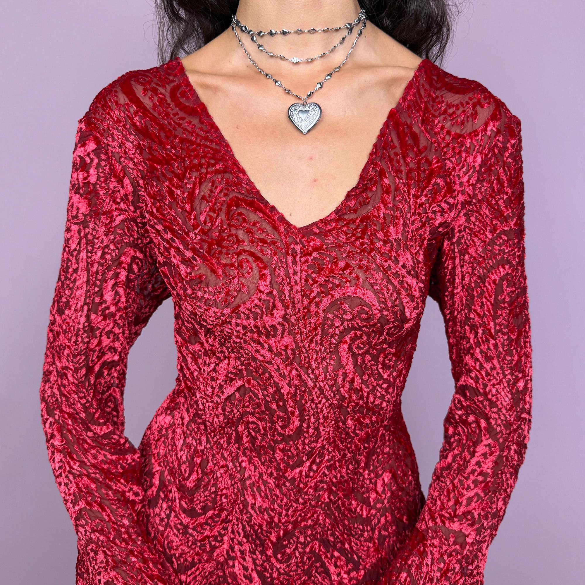 This vintage 2000s top features a dramatic red velvet devoré burnout design with sheer detailing. Styled with asymmetric bell sleeves, a fitted silhouette, and a flared hem, it creates a striking romantic look. Perfect for parties, festivals, or statement evening wear, this Y2K piece captures glamorous gothic energy with artistic flair. A rare archival French design. Made from a stretchy polyester blend devoré velvet. Excellent vintage condition.