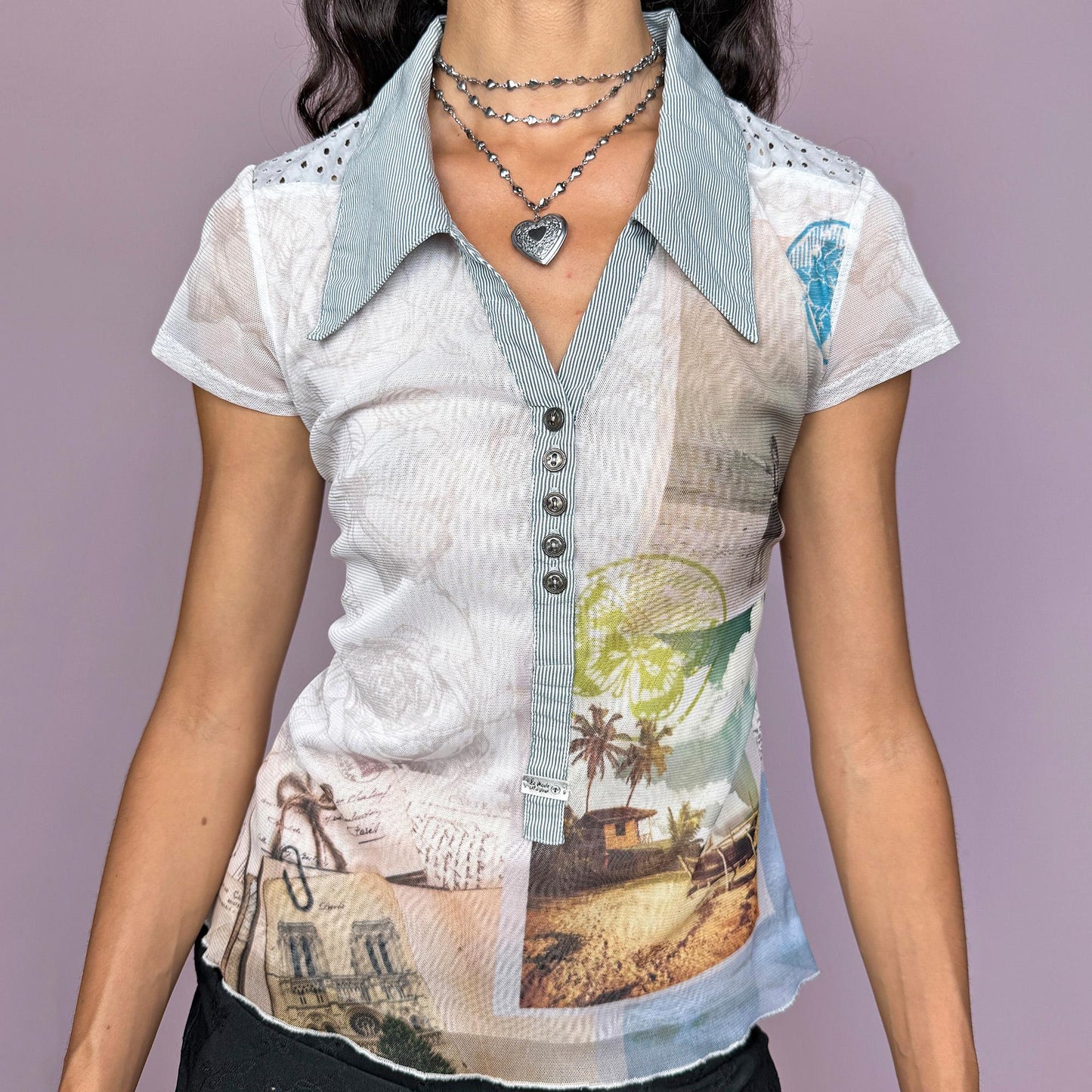 This vintage 2000s French mesh top features a unique landscape-abstract print, short sleeves, and a sharp striped collar. Designed with a button front, semi-sheer stretch fabric, and a striped back panel, it captures the deconstructed city aesthetic and weird-girl Y2K vibe. Perfect for casual summer outfits or layered statement styling. Made from a polyester and cotton stretch blend. Great vintage condition.