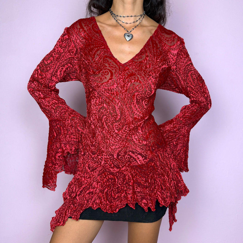 This vintage 2000s top features a dramatic red velvet devoré burnout design with sheer detailing. Styled with asymmetric bell sleeves, a fitted silhouette, and a flared hem, it creates a striking romantic look. Perfect for parties, festivals, or statement evening wear, this Y2K piece captures glamorous gothic energy with artistic flair. A rare archival French design. Made from a stretchy polyester blend devoré velvet. Excellent vintage condition.