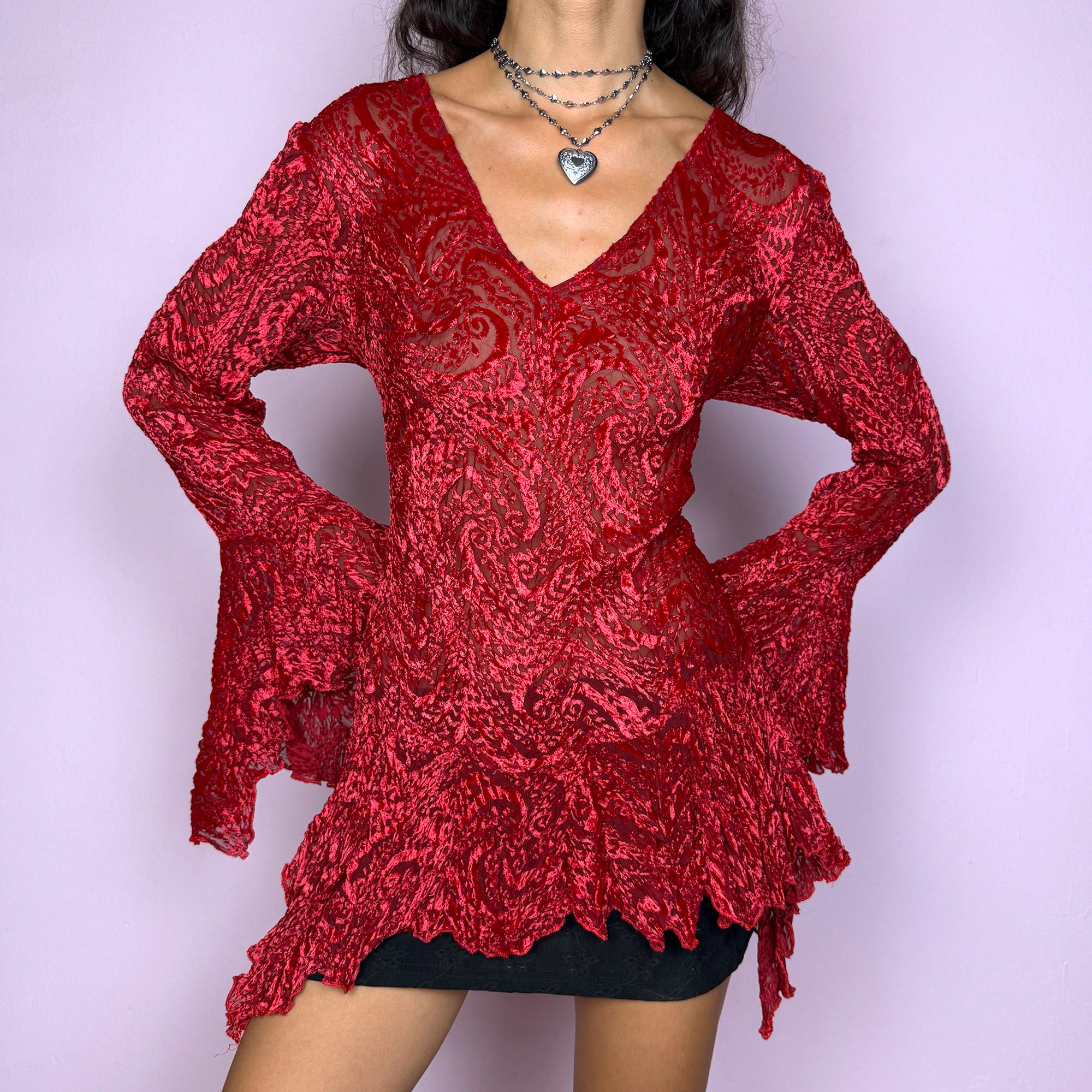This vintage 2000s top features a dramatic red velvet devoré burnout design with sheer detailing. Styled with asymmetric bell sleeves, a fitted silhouette, and a flared hem, it creates a striking romantic look. Perfect for parties, festivals, or statement evening wear, this Y2K piece captures glamorous gothic energy with artistic flair. A rare archival French design. Made from a stretchy polyester blend devoré velvet. Excellent vintage condition.