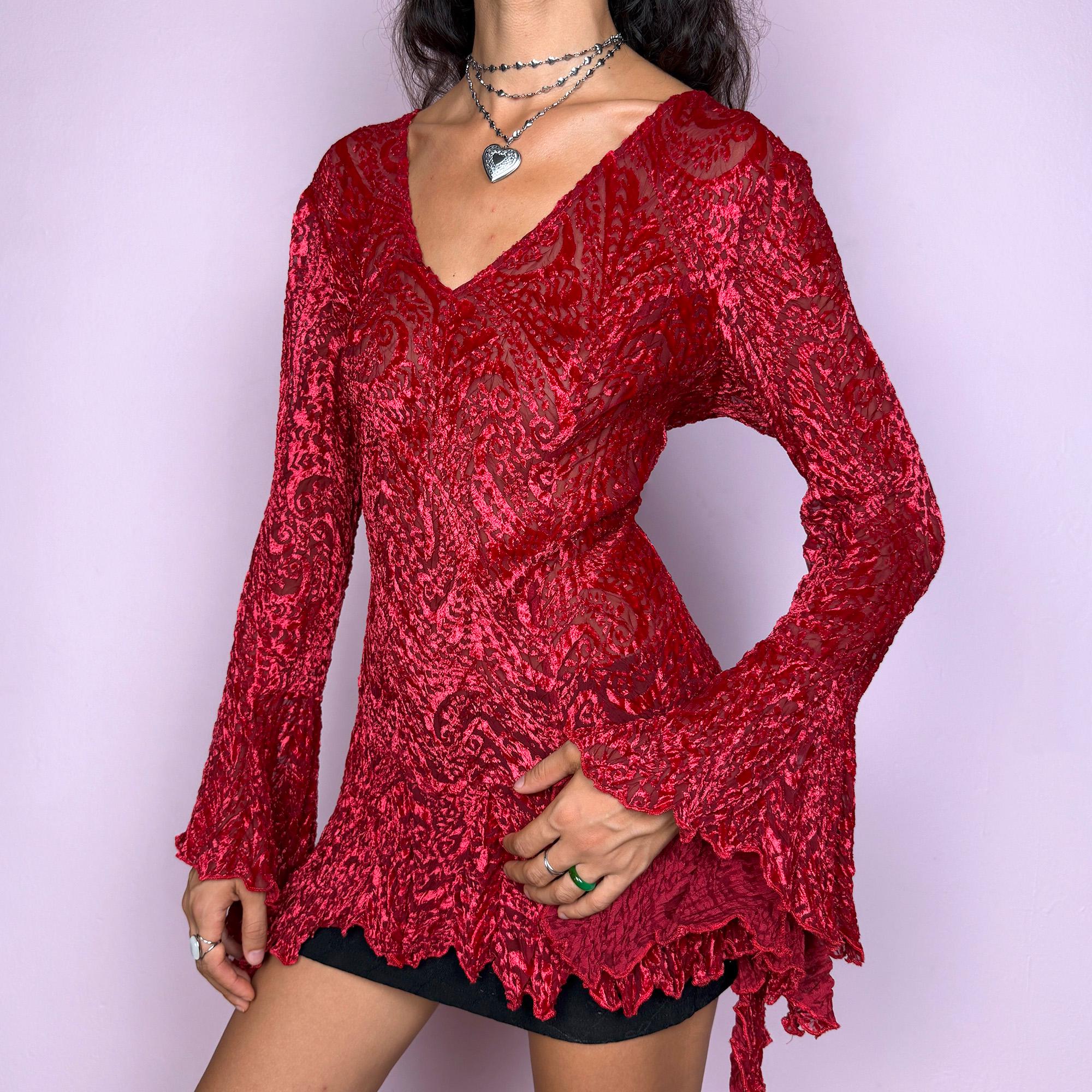 This vintage 2000s top features a dramatic red velvet devoré burnout design with sheer detailing. Styled with asymmetric bell sleeves, a fitted silhouette, and a flared hem, it creates a striking romantic look. Perfect for parties, festivals, or statement evening wear, this Y2K piece captures glamorous gothic energy with artistic flair. A rare archival French design. Made from a stretchy polyester blend devoré velvet. Excellent vintage condition.