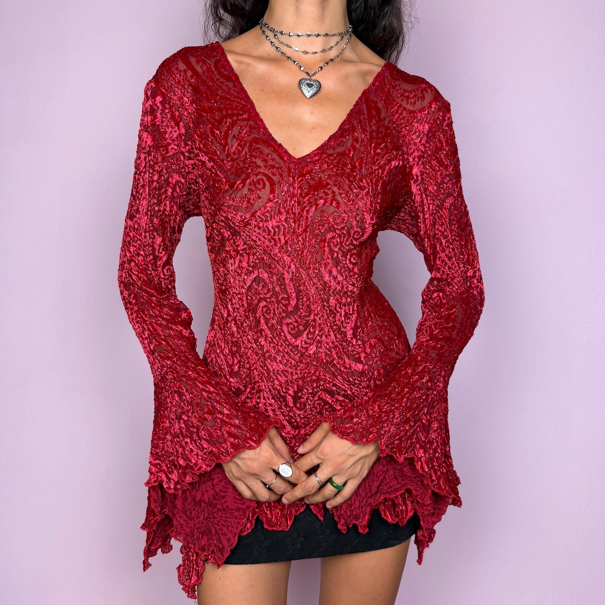 This vintage 2000s top features a dramatic red velvet devoré burnout design with sheer detailing. Styled with asymmetric bell sleeves, a fitted silhouette, and a flared hem, it creates a striking romantic look. Perfect for parties, festivals, or statement evening wear, this Y2K piece captures glamorous gothic energy with artistic flair. A rare archival French design. Made from a stretchy polyester blend devoré velvet. Excellent vintage condition.
