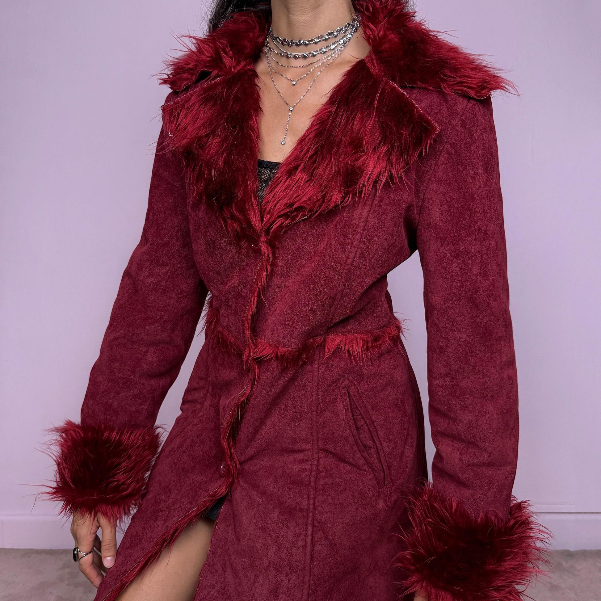 This vintage 2000s dark red Penny Lane coat features plush faux fur trim at the collar and cuffs, front buttons, and side pockets. Made from soft faux suede polyester, it captures glamorous Y2K fairy energy with a bold, whimsical edge. Perfect for winter styling, festivals, or statement nights out. Made from polyester faux suede. Excellent vintage condition.