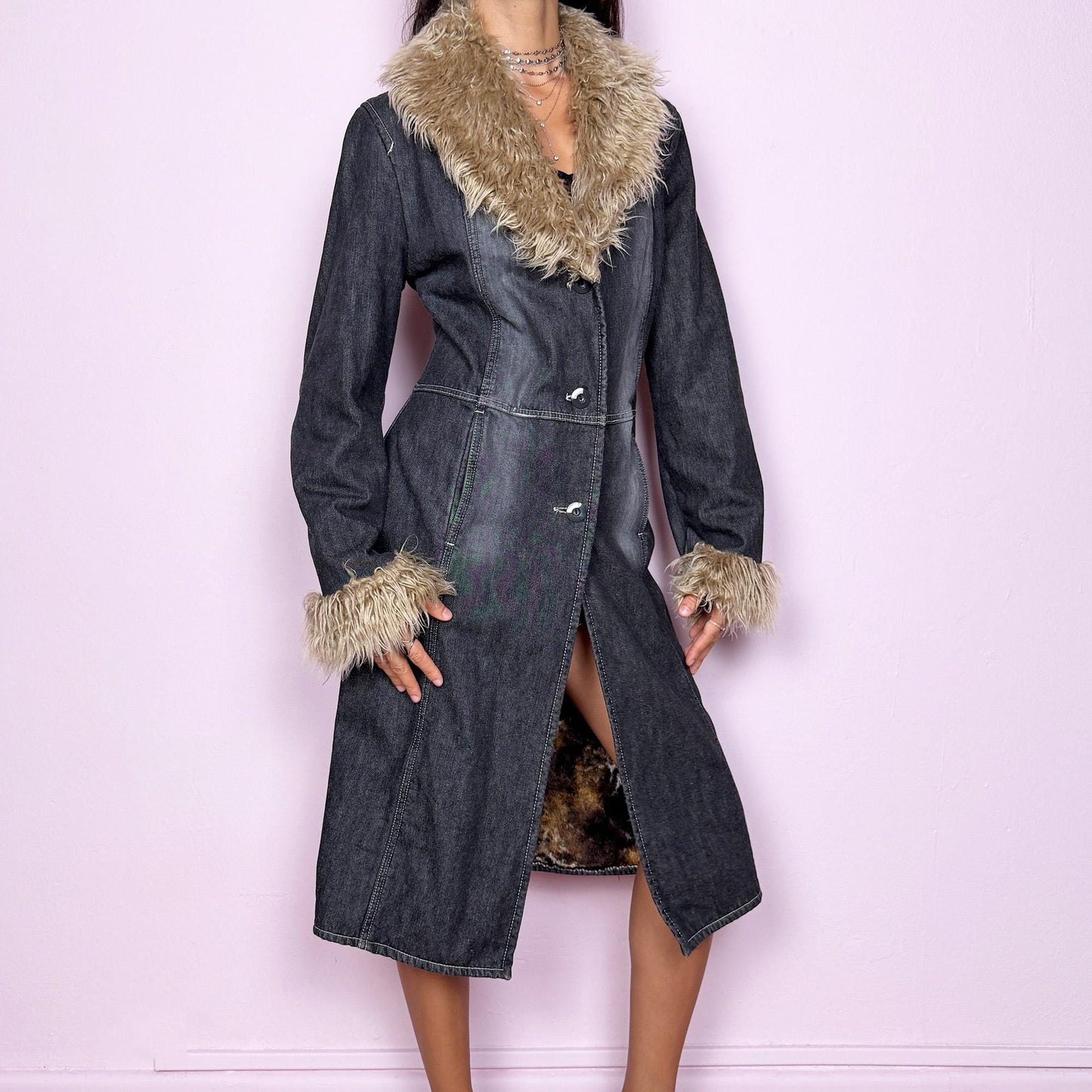 This vintage 2000s long denim Penny Lane coat channels true Y2K edge with a dark gray wash and plush beige faux fur trim along the collar and cuffs. Fully lined in soft brown faux fur for warmth and contrast, it features front button closures, side pockets, and a flattering fitted cut that elongates the silhouette. Effortlessly blending streetwear and bohemian allure, this coat is perfect for winter nights, club looks, or everyday grunge layering.