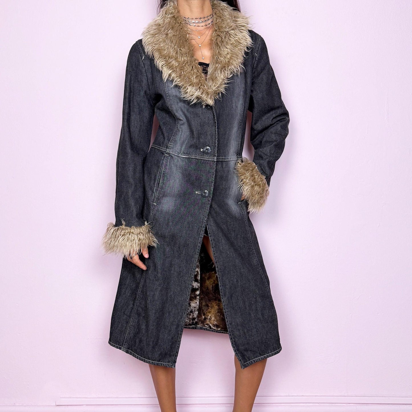 This vintage 2000s long denim Penny Lane coat channels true Y2K edge with a dark gray wash and plush beige faux fur trim along the collar and cuffs. Fully lined in soft brown faux fur for warmth and contrast, it features front button closures, side pockets, and a flattering fitted cut that elongates the silhouette. Effortlessly blending streetwear and bohemian allure, this coat is perfect for winter nights, club looks, or everyday grunge layering.