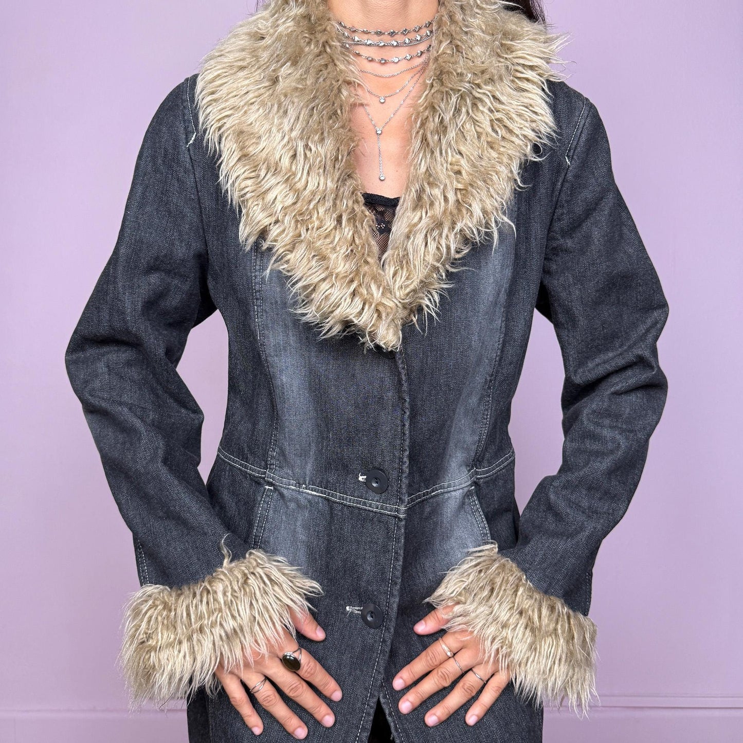 This vintage 2000s long denim Penny Lane coat channels true Y2K edge with a dark gray wash and plush beige faux fur trim along the collar and cuffs. Fully lined in soft brown faux fur for warmth and contrast, it features front button closures, side pockets, and a flattering fitted cut that elongates the silhouette. Effortlessly blending streetwear and bohemian allure, this coat is perfect for winter nights, club looks, or everyday grunge layering.