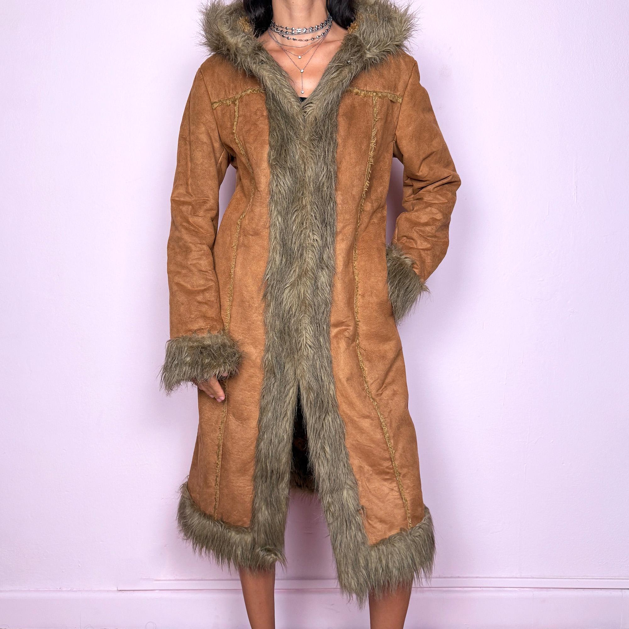 This vintage 2000s brown faux suede long coat features a hooded Afghan Penny Lane silhouette with plush beige faux fur trim and cuffs. Fitted through the body with hidden hook closure and side pockets, it delivers a warm, bohemian look perfect for autumn and winter layering. Made from faux suede with faux fur lining. Great vintage condition.