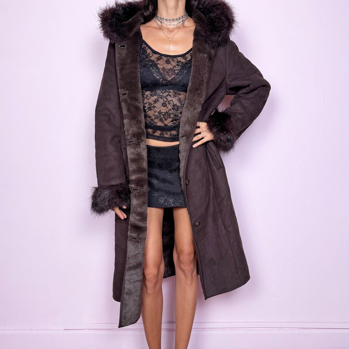 This stunning vintage 2000s dark brown-purple faux suede long coat features a hooded Penny Lane cut with a plush faux fur collar, cuffs, and full interior. It also includes a button front and pockets. Its rich tone evokes dark whimsy and fairycore night energy, blending goth romance with bohemian warmth. Made from faux suede with faux fur lining. Great vintage condition.