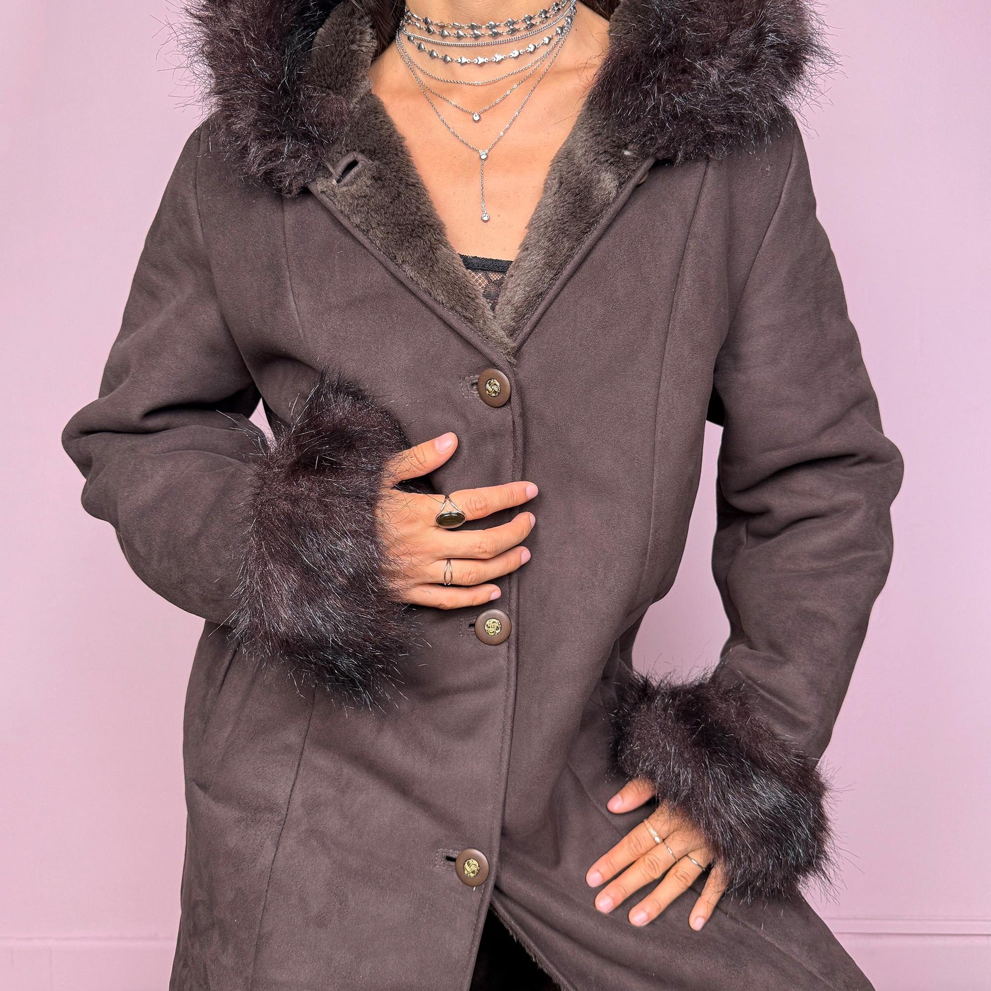 This stunning vintage 2000s dark brown-purple faux suede long coat features a hooded Penny Lane cut with a plush faux fur collar, cuffs, and full interior. It also includes a button front and pockets. Its rich tone evokes dark whimsy and fairycore night energy, blending goth romance with bohemian warmth. Made from faux suede with faux fur lining. Great vintage condition.