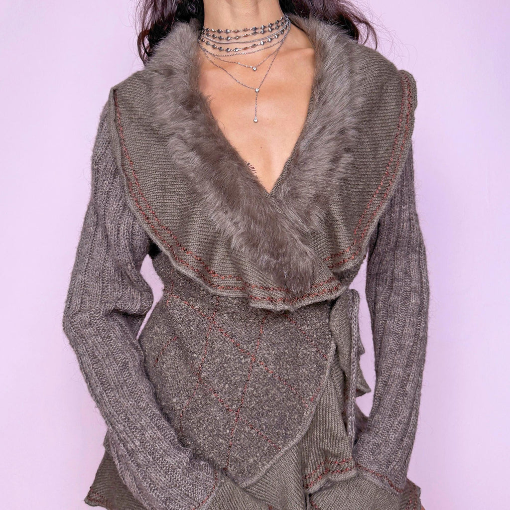 This vintage 2000s taupe gray-brown ruffle wrap cardigan features a dramatic faux fur collar, bell sleeves, and a tie-front waist. Crafted in a mohair–wool–acrylic–polyester blend, it offers plush warmth and sculptural drape. The asymmetrical hem and contrast stitching evoke Y2K fairycore romance with a cozy, whimsical twist. Perfect for winter layering or statement street styling. A rare collector’s knit jacket. Made from mohair wool acrylic polyester blend. Excellent vintage condition.