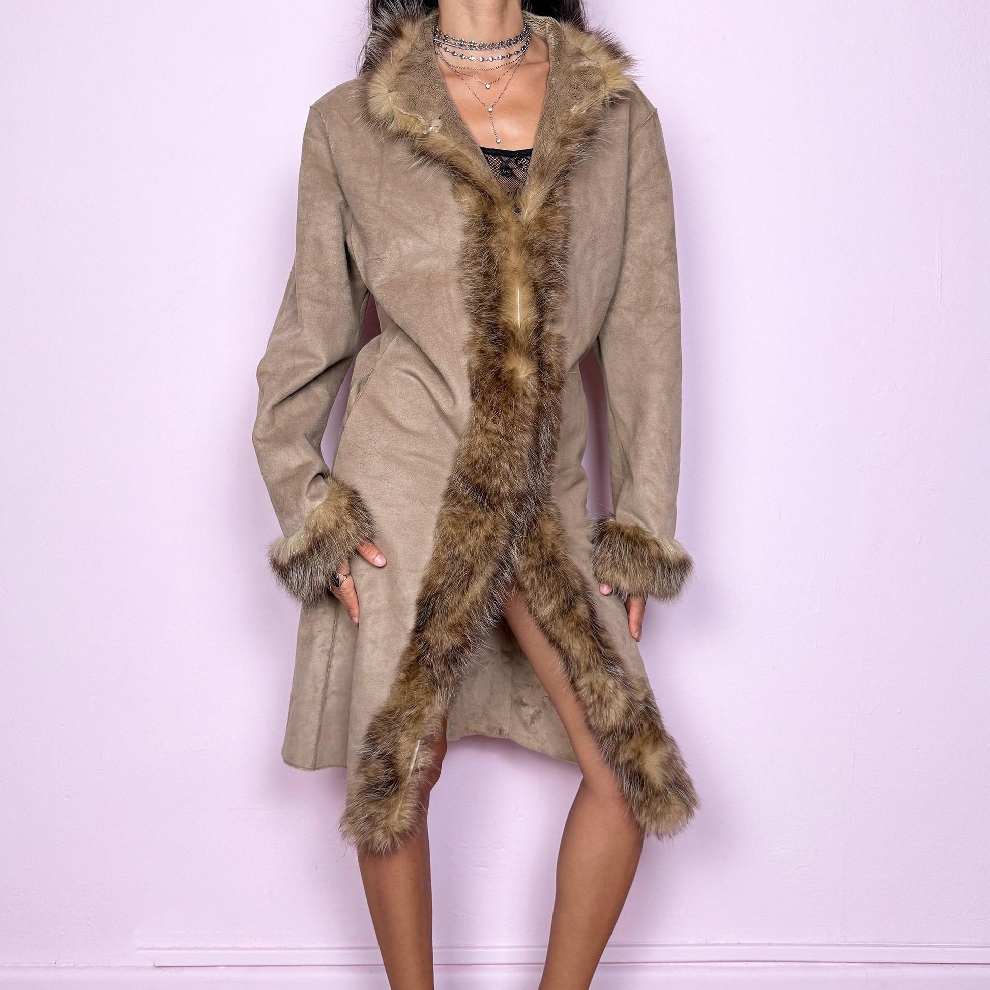 This vintage beige Penny Lane coat features a real fur trim along the collar and cuffs, faux suede body, hook closure, and side pockets. A 70s-inspired Afghan silhouette that channels boho elegance and winter romance, perfect for statement cold-weather styling. Great vintage condition.