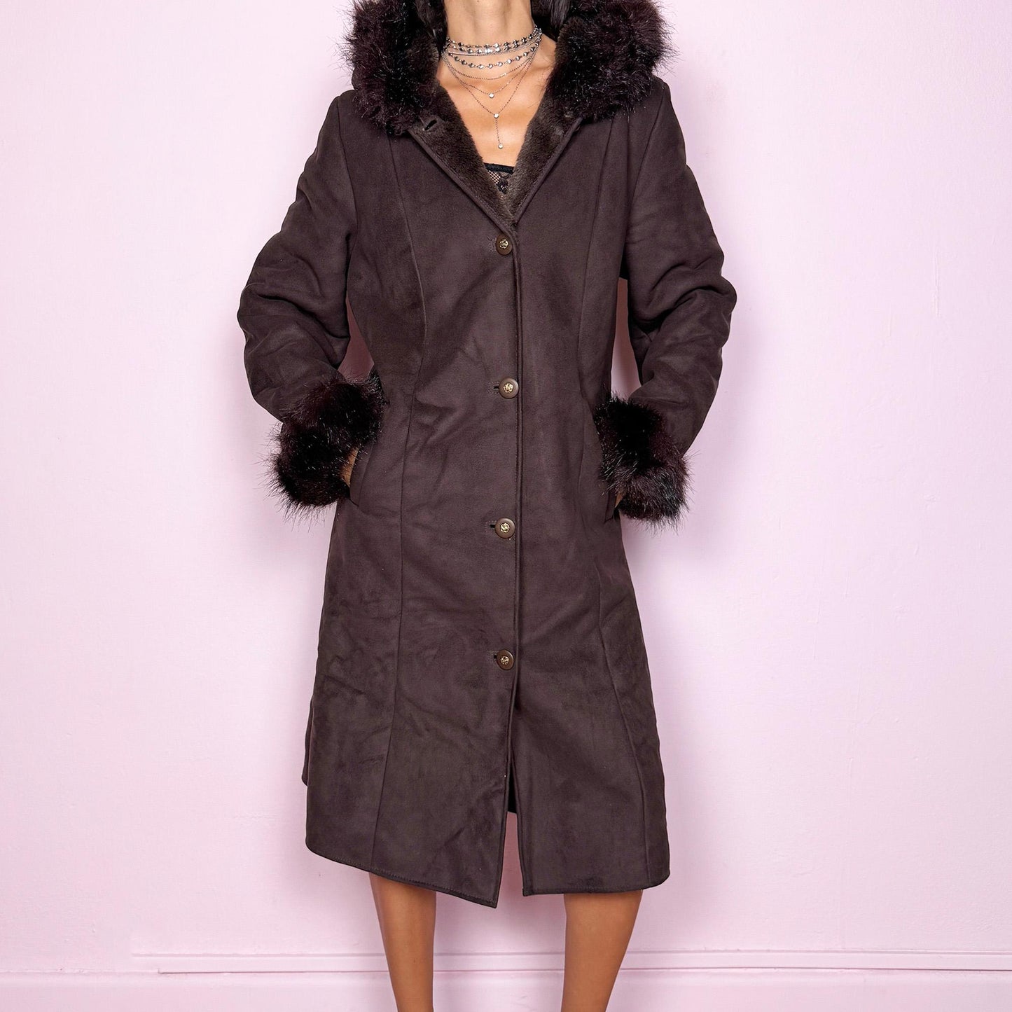 This stunning vintage 2000s dark brown-purple faux suede long coat features a hooded Penny Lane cut with a plush faux fur collar, cuffs, and full interior. It also includes a button front and pockets. Its rich tone evokes dark whimsy and fairycore night energy, blending goth romance with bohemian warmth. Made from faux suede with faux fur lining. Great vintage condition.