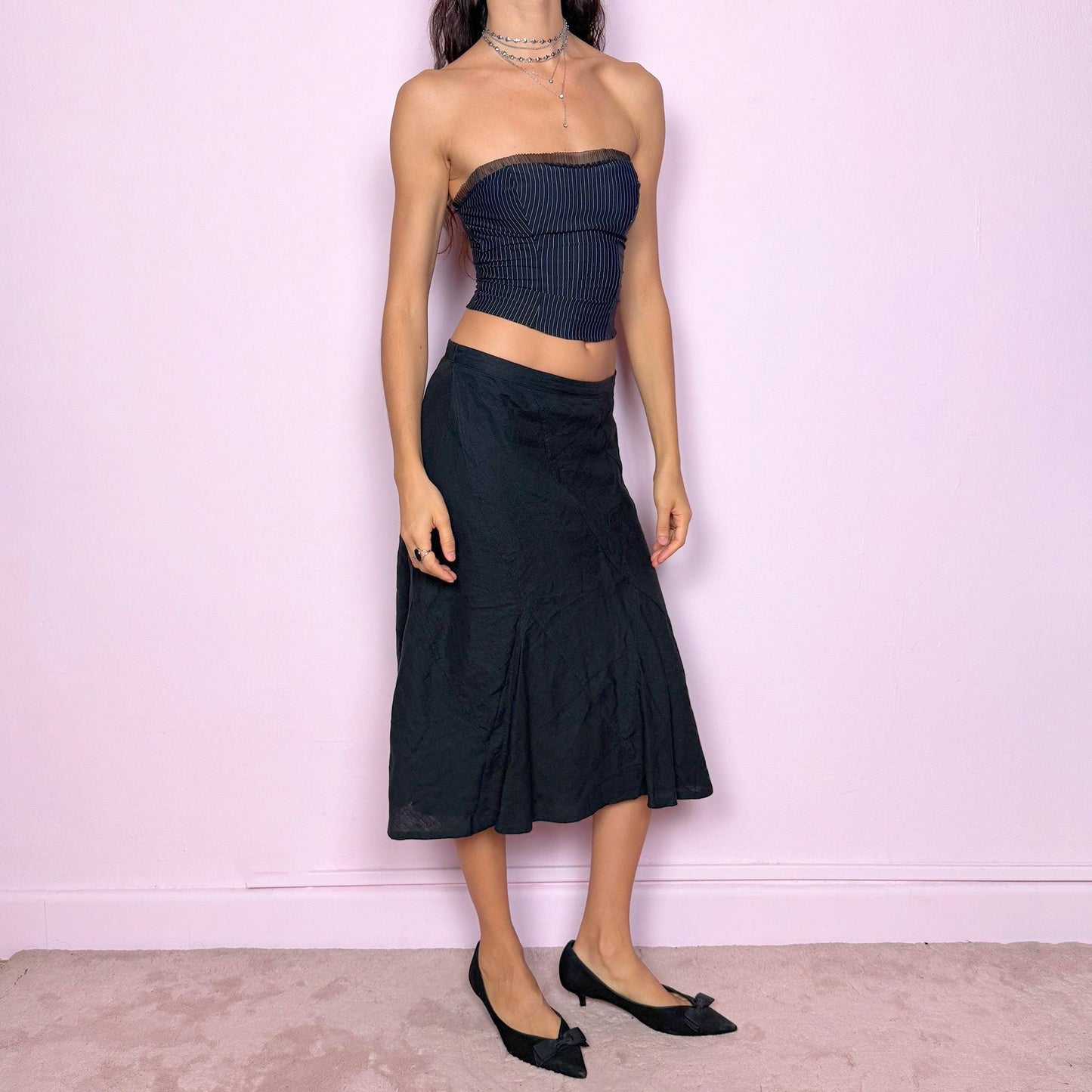 This vintage black flared linen midi skirt offers a timeless, structured silhouette with a side zipper closure and no stretch. Can be worn low-rise for size XS/S or high-rise for size M, adapting easily to different fits. A refined minimalist piece ideal for elegant summer styling, workwear, or casual sophistication. Made from 100% linen non-stretch. Great vintage condition.