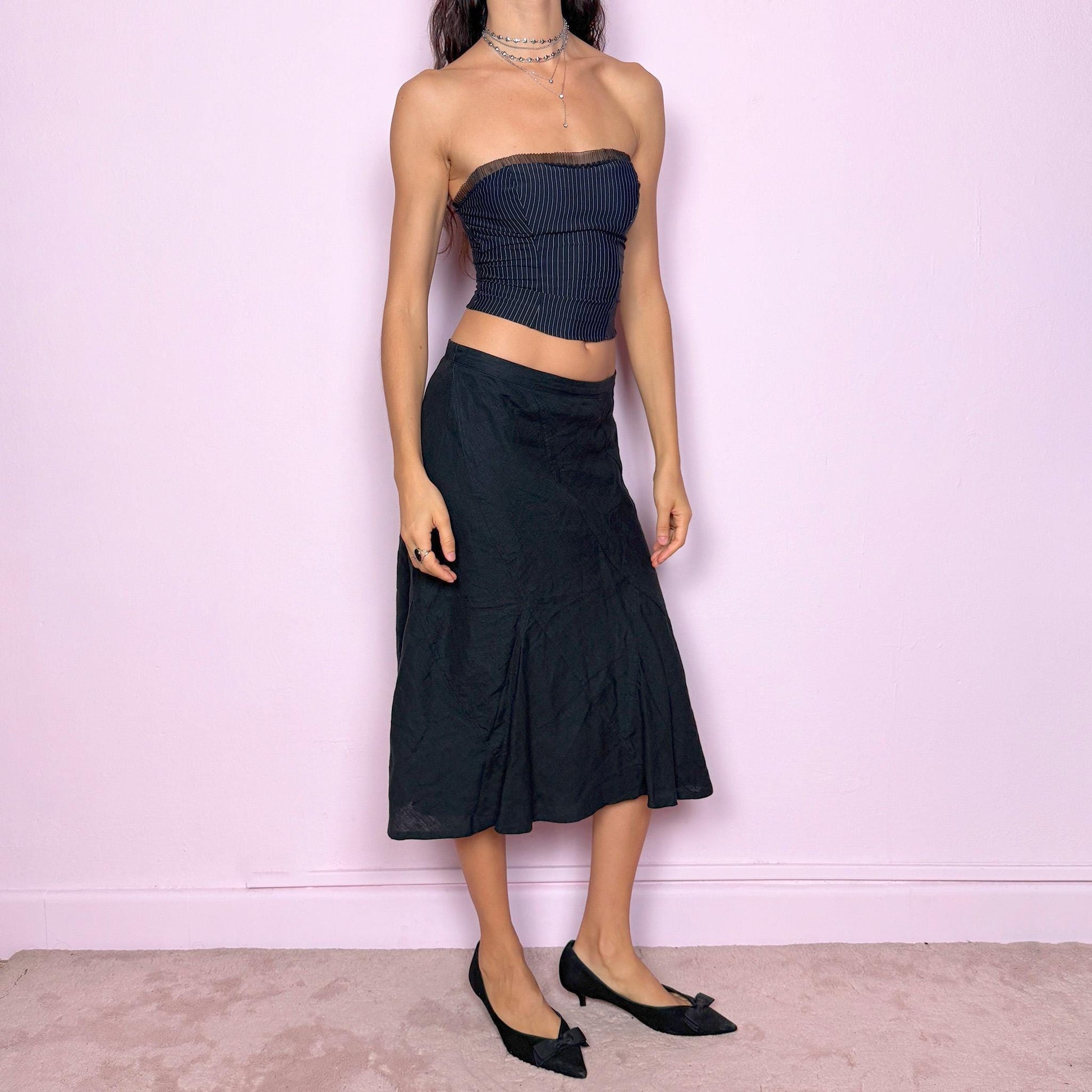 This vintage black flared linen midi skirt offers a timeless, structured silhouette with a side zipper closure and no stretch. Can be worn low-rise for size XS/S or high-rise for size M, adapting easily to different fits. A refined minimalist piece ideal for elegant summer styling, workwear, or casual sophistication. Made from 100% linen non-stretch. Great vintage condition.