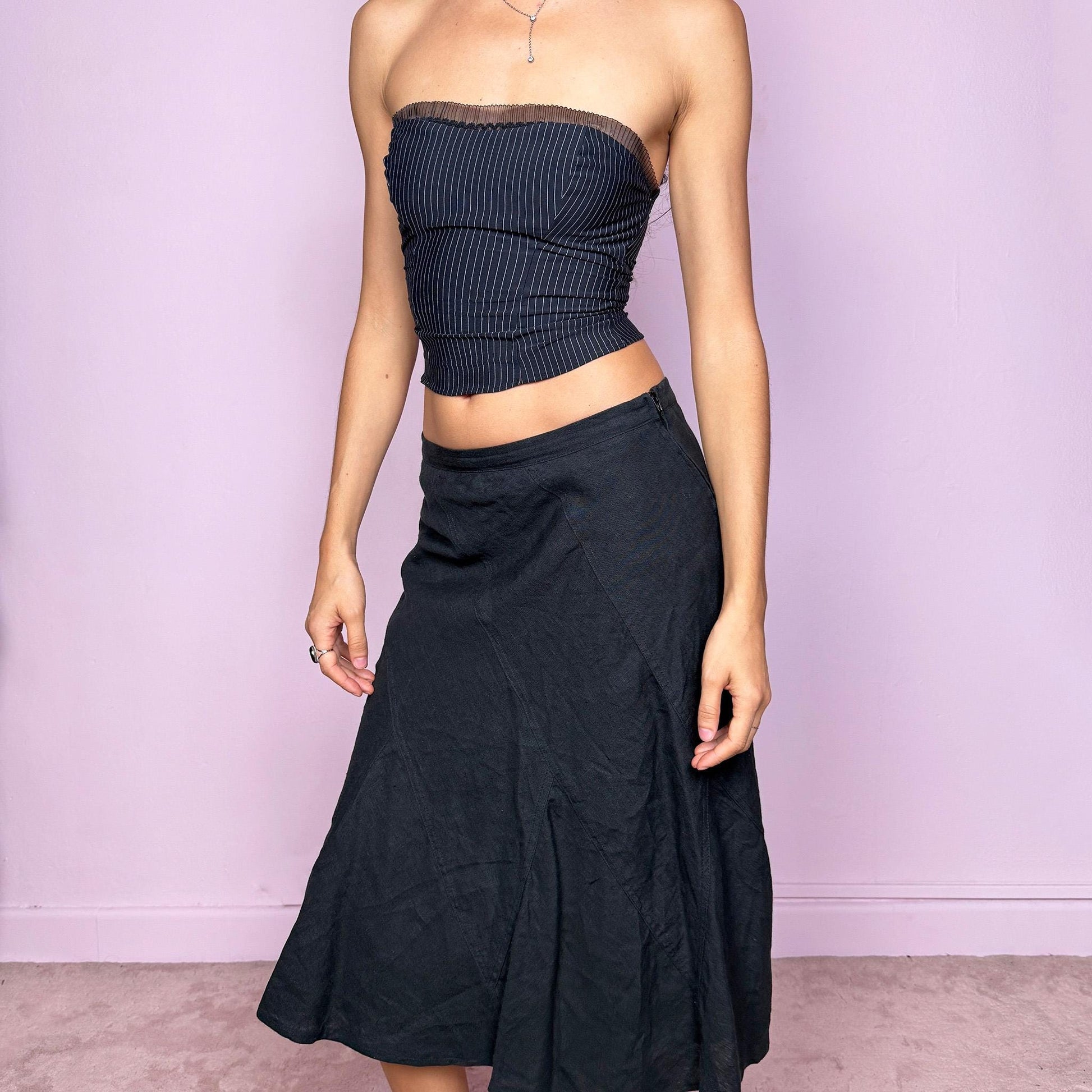 This vintage black flared linen midi skirt offers a timeless, structured silhouette with a side zipper closure and no stretch. Can be worn low-rise for size XS/S or high-rise for size M, adapting easily to different fits. A refined minimalist piece ideal for elegant summer styling, workwear, or casual sophistication. Made from 100% linen non-stretch. Great vintage condition.