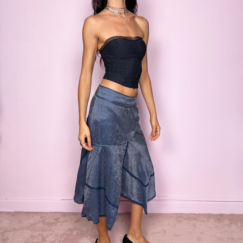 This vintage 2000s blue striped patchwork midi skirt features an asymmetric hemline, delicate lace trim details, and a side zipper closure. Lightweight and non-stretch, it offers a breezy, formal look ideal for summer styling. Can be worn low-rise for size XS or mid-rise for size S, creating an elegant and modern silhouette. Excellent vintage condition.
