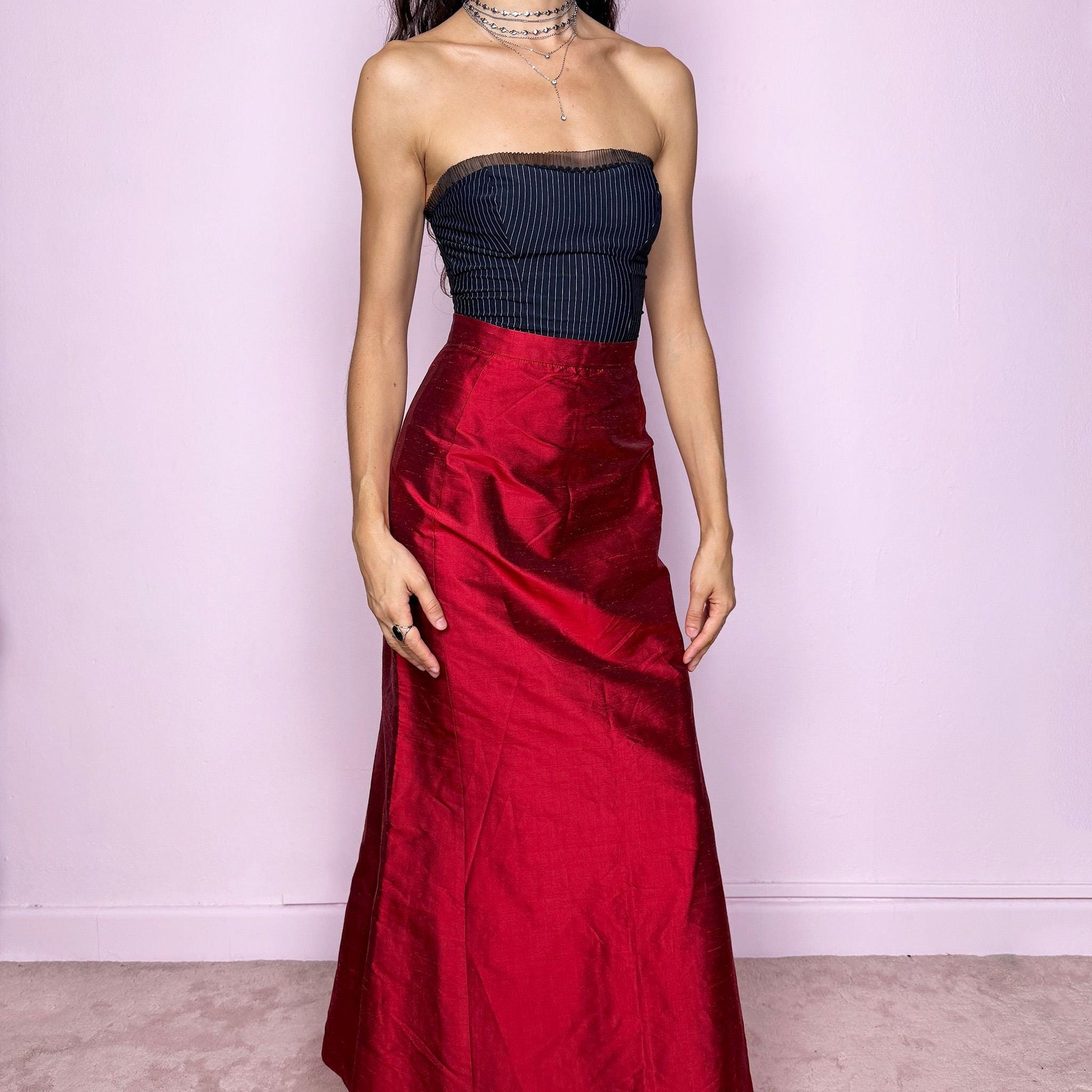This vintage 90s red shiny maxi skirt features a sculpted mermaid silhouette with a high-waisted fit and back zipper closure. Made in France from non-stretch polyester, it radiates diva allure with a formal, romantic tone, perfect for gala nights, prom, or elegant evening events. A stunning statement piece of timeless sophistication. Made from non-stretch polyester. Great vintage condition.