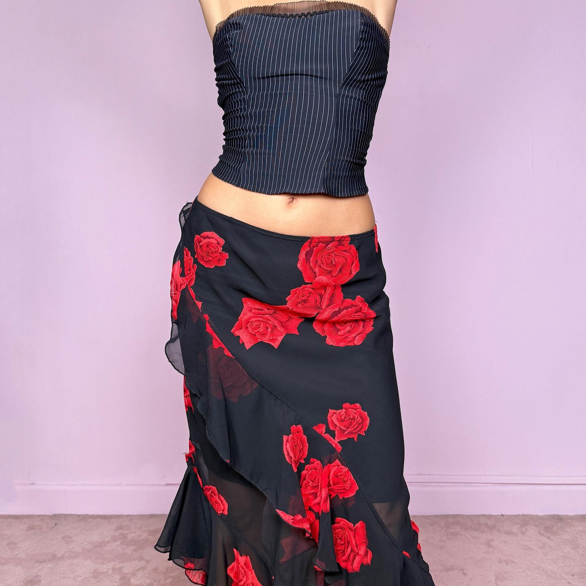 This vintage 90s black midi skirt features bold red rose floral prints, cascading ruffles, and a soft elastic waist for comfort and movement. Its romantic coquette design blends elegance and sensuality, perfect for formal events, summer nights, or evening parties. Can be worn low- or mid-rise for size L. Great vintage condition.