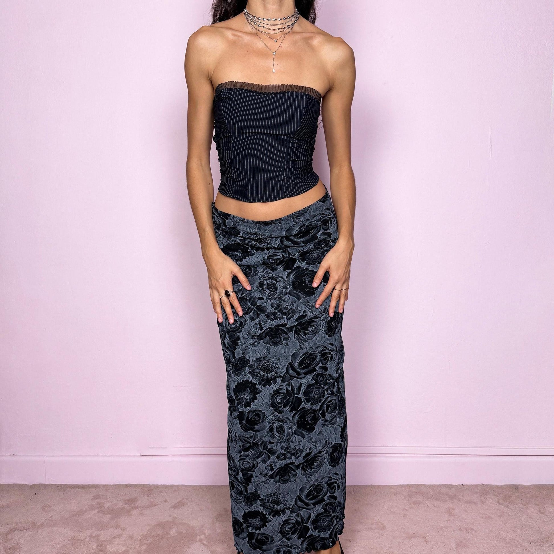 This vintage 2000s black and gray floral rose print midi skirt features a soft elastic waist and a slightly body-hugging silhouette. Made in Europe from a polyamide blend, it channels whimsigoth and 90s grunge-inspired elegance, perfect for everyday wear or dark romantic styling. Fits mid- to low-rise for size S. Excellent vintage condition.