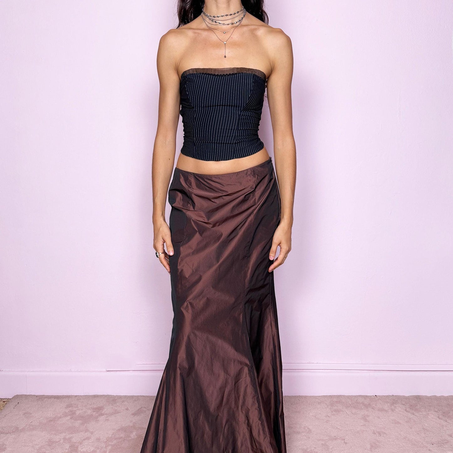This vintage 90s brown satin-style iridescent maxi skirt features a dramatic mermaid silhouette with a side zipper closure. Crafted from structured non-stretch fabric, it shimmers beautifully under light, creating a darkly romantic and whimsical look. Perfect for galas, prom, or formal night events. Fits high-waisted for size M. Excellent vintage condition.