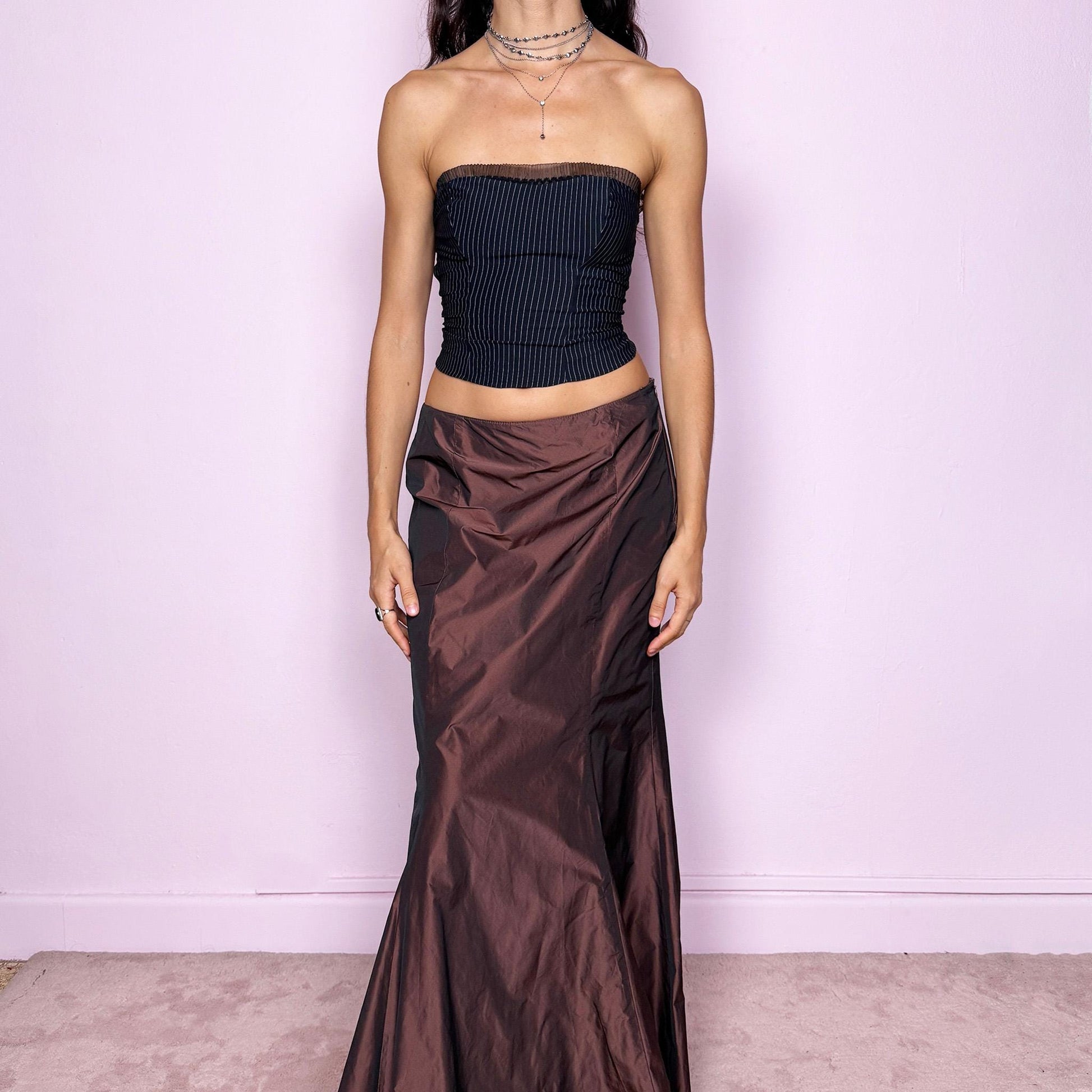 This vintage 90s brown satin-style iridescent maxi skirt features a dramatic mermaid silhouette with a side zipper closure. Crafted from structured non-stretch fabric, it shimmers beautifully under light, creating a darkly romantic and whimsical look. Perfect for galas, prom, or formal night events. Fits high-waisted for size M. Excellent vintage condition.