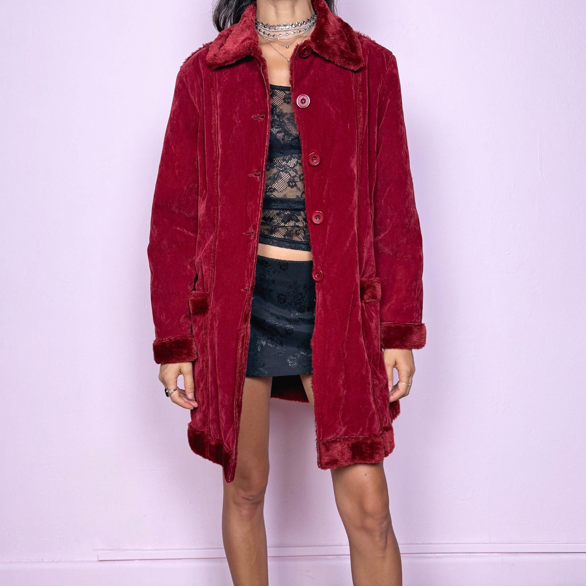 This vintage 2000s red faux suede coat features a plush faux fur lining, collar, and cuffs inspired by the iconic Penny Lane silhouette. Designed with front pockets and button closure, it captures whimsical Y2K winter charm with a boho-grunge edge, perfect for festivals or statement cold-weather styling. Made from polyester faux suede and faux fur. Great vintage condition.