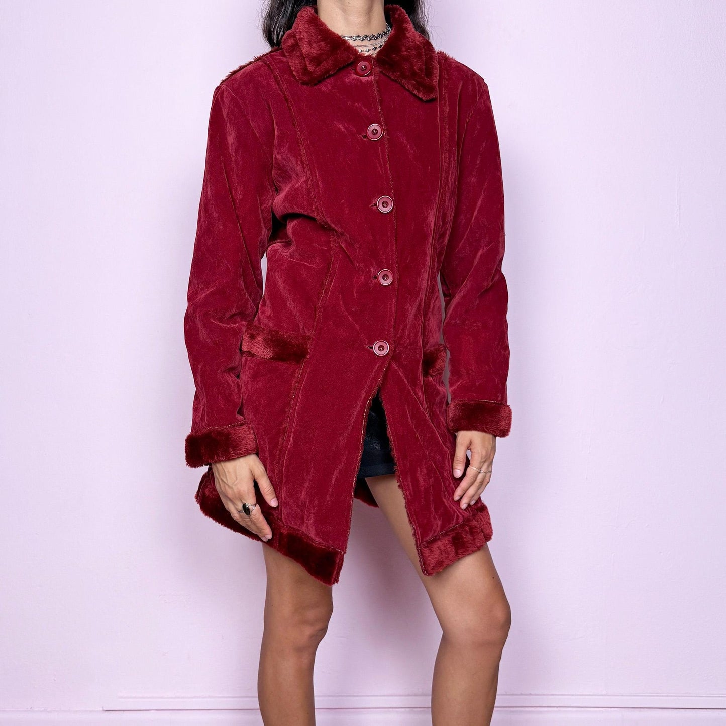 This vintage 2000s red faux suede coat features a plush faux fur lining, collar, and cuffs inspired by the iconic Penny Lane silhouette. Designed with front pockets and button closure, it captures whimsical Y2K winter charm with a boho-grunge edge, perfect for festivals or statement cold-weather styling. Made from polyester faux suede and faux fur. Great vintage condition.