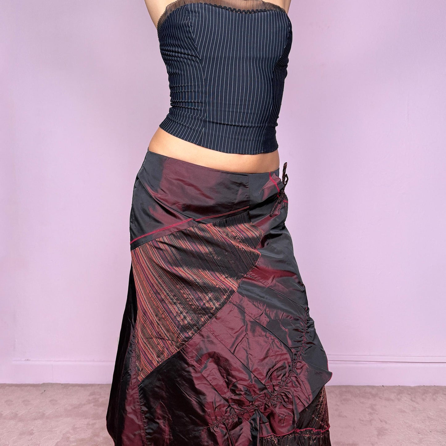 This stunning vintage 2000s maroon-burgundy flared midi skirt features a layered patchwork design with ruched detailing, ruffle hem, and back zipper closure. A whimsical fusion of fairy-grunge and deconstructed Y2K elegance, perfect for autumn nights, creative gatherings, or statement everyday wear. A rare, collectible piece with dark romance allure. It can be worn low to mid rise for size XS/S or high waisted for size M. Made from polyester acetate blend. Excellent vintage condition.