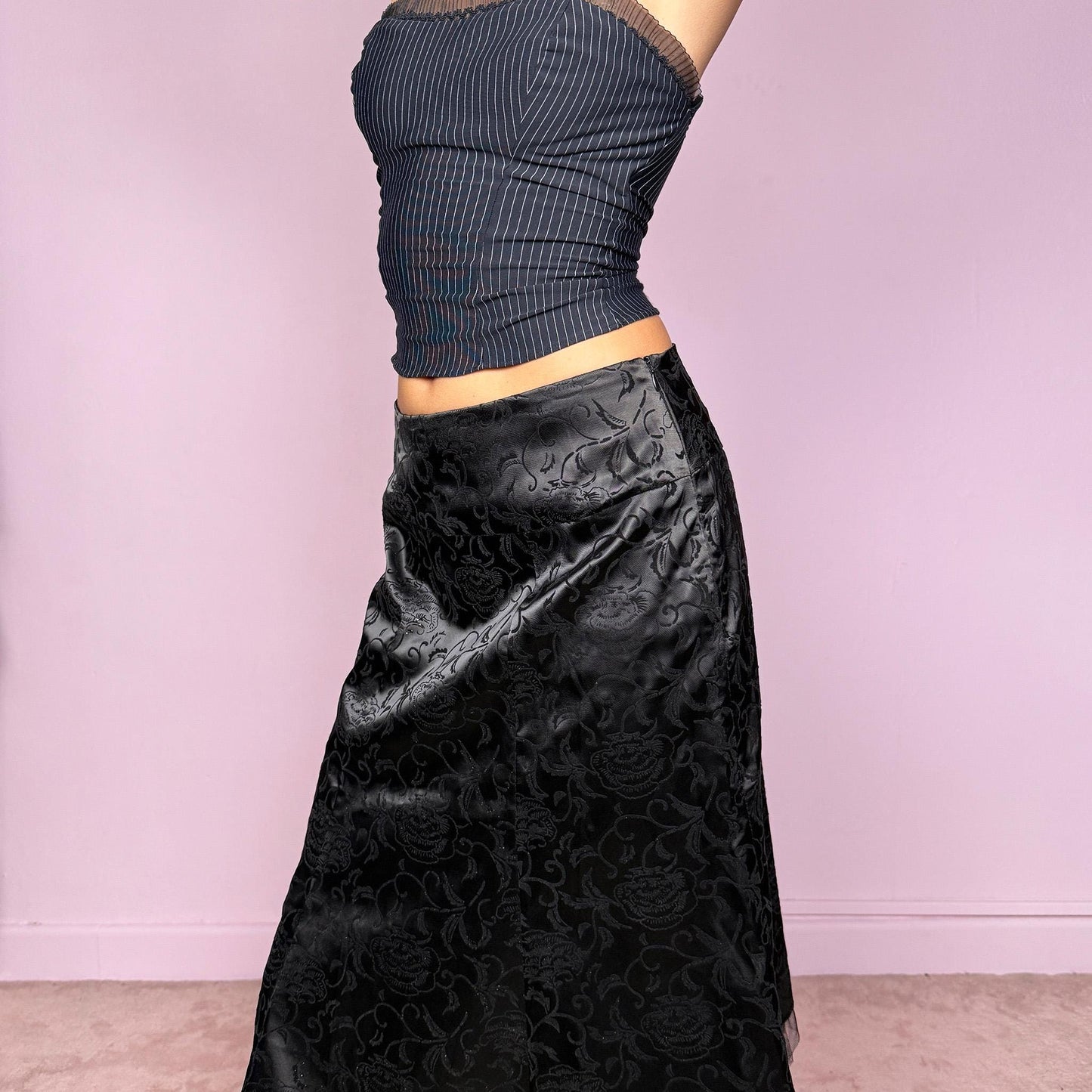 This vintage 2000s black satin and velvet floral jacquard midi skirt features a flared cut, glitter accents, and a soft tulle ruffle hem. With a side zipper closure and no stretch, it can be worn high-rise for size M or mid-rise for XS/S. A striking formal piece blending dark romantic textures, perfect for night events or cocktail styling. Made from non-stretch polyester. Excellent vintage condition.