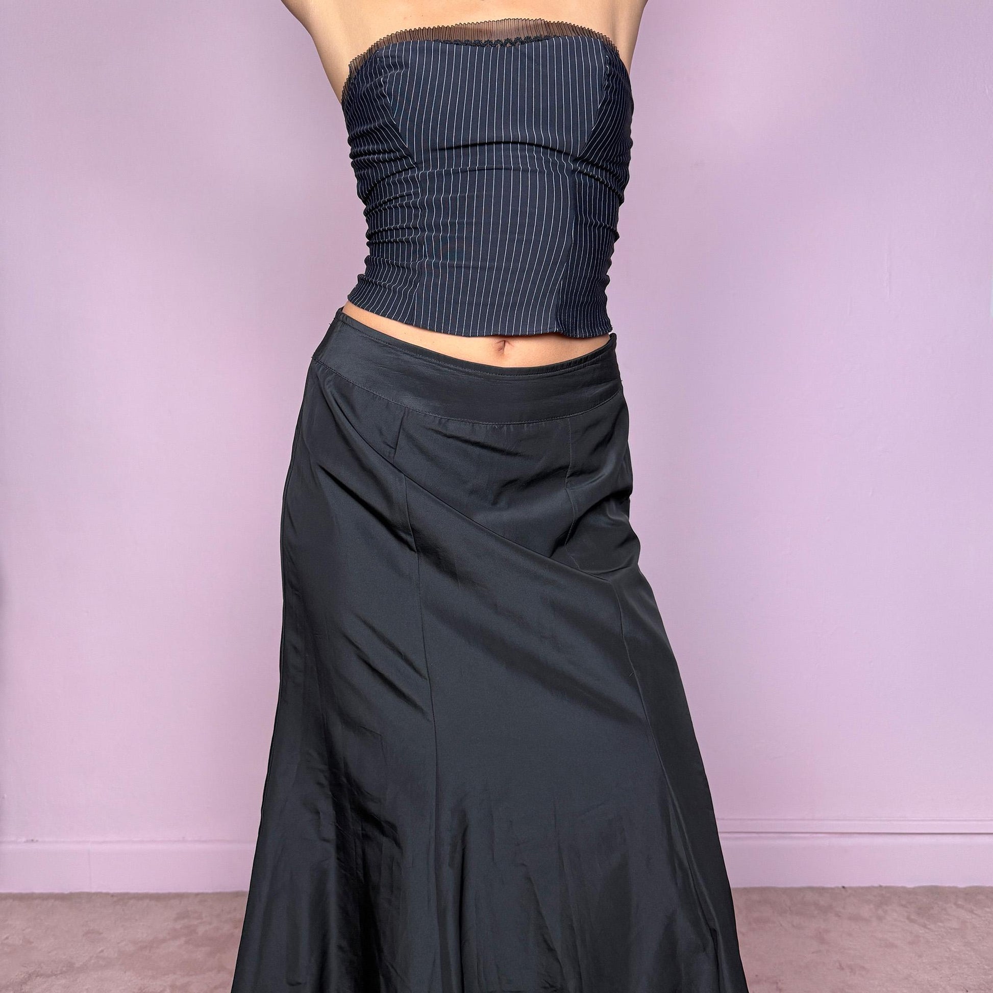 This stunning vintage 90s black silk-blend maxi skirt features a sculpted mermaid silhouette with a side zipper closure and no stretch. Made in Italy, it drapes fluidly for a dramatic, refined look, perfect for gala nights, prom, or dark romantic styling. Fits high-waisted for size S. Made from a silk blend non-stretch fabric. Excellent vintage condition.