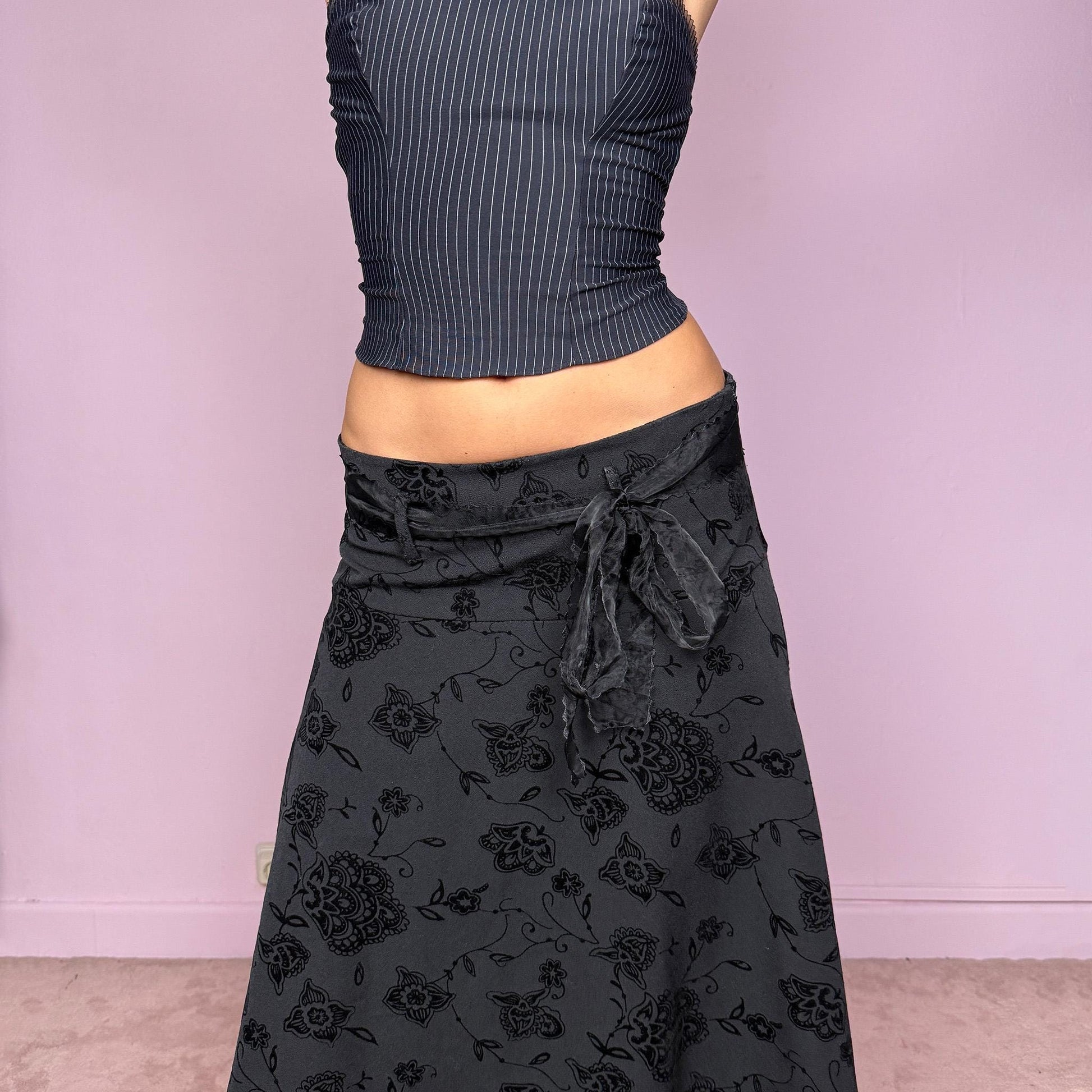 This vintage 2000s black jacquard brocade midi skirt features floral and paisley velvet details, lace trim at the hem, and a stretchy fit with side zipper closure. Made in Italy from a viscose polyester blend, it captures dark romance with a formal yet cute coquette allure. Ideal for office wear, elegant night parties, or refined events. Can be worn high/mid-rise for M size or low-rise for S size. Great vintage condition.